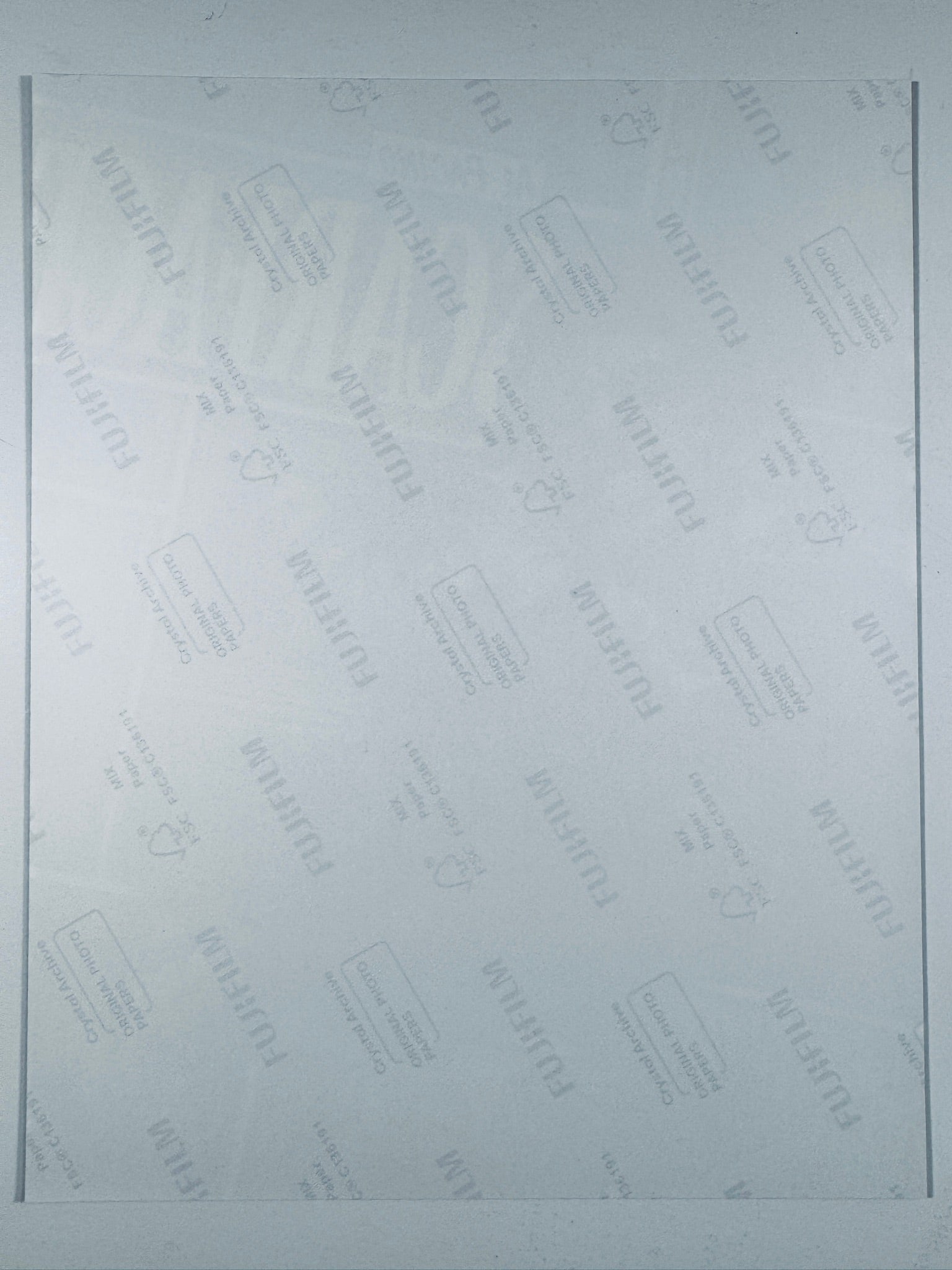 The plain white reverse side of a photographic print showing translucent Fujifilm crystal archive paper watermarks and logos.