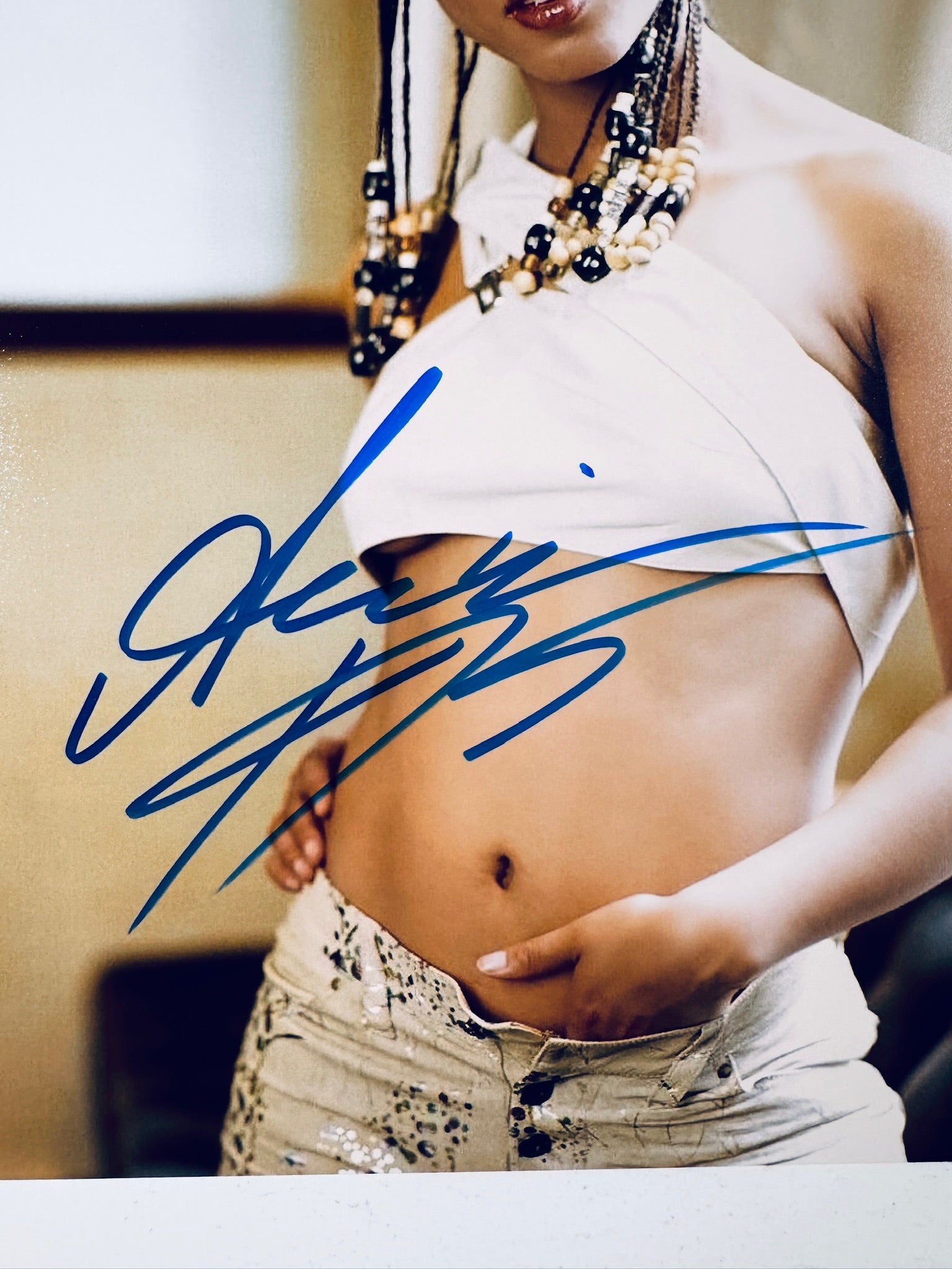 Close-up view of Alicia Keys's blue signature across her waist and midsection on the promotional photograph.