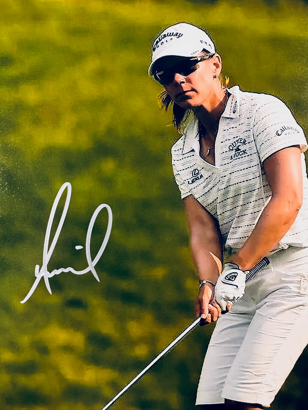Close-up view of Annika Sorenstam's signature in white marker on her professional golf promotional photo.