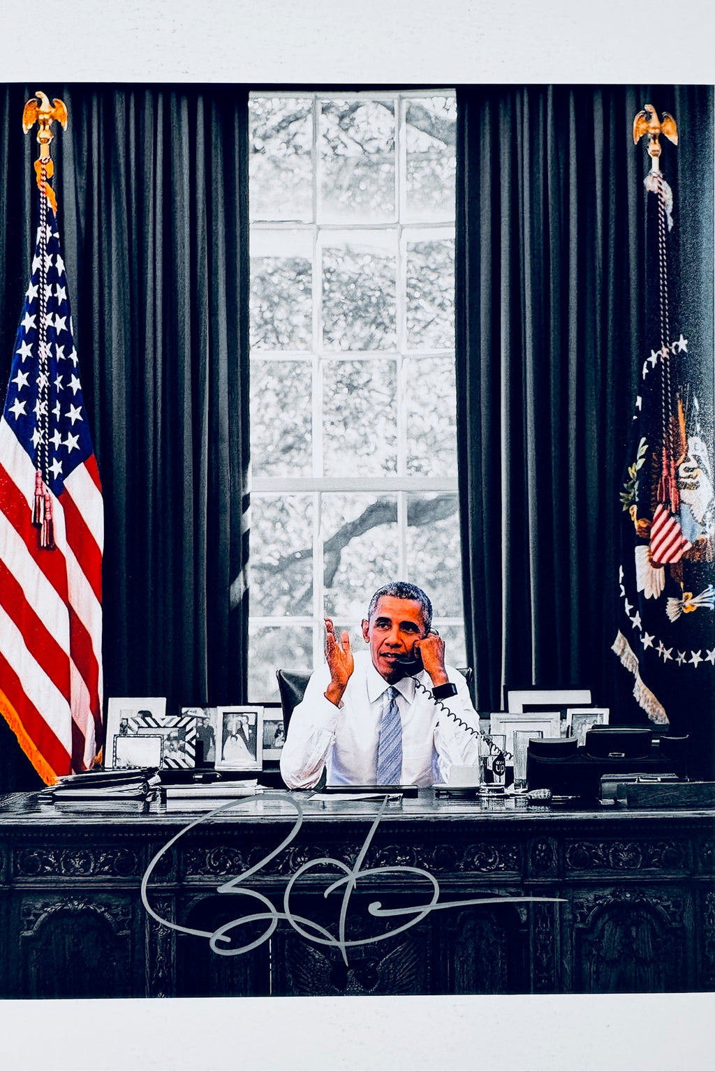Barack Obama hand-signed 8x10 matte photo in the Oval Office seated at the Resolute Desk talking on the phone.