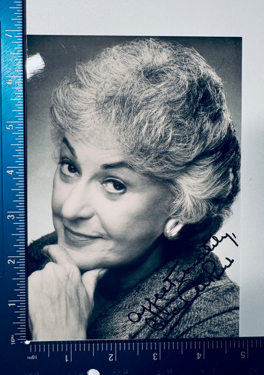 Black and white vintage headshot portrait of actress Bea Arthur hand-signed "Affectionately, Bea Arthur" in black ink, shown next to a blue measuring ruler verifying item dimensions.