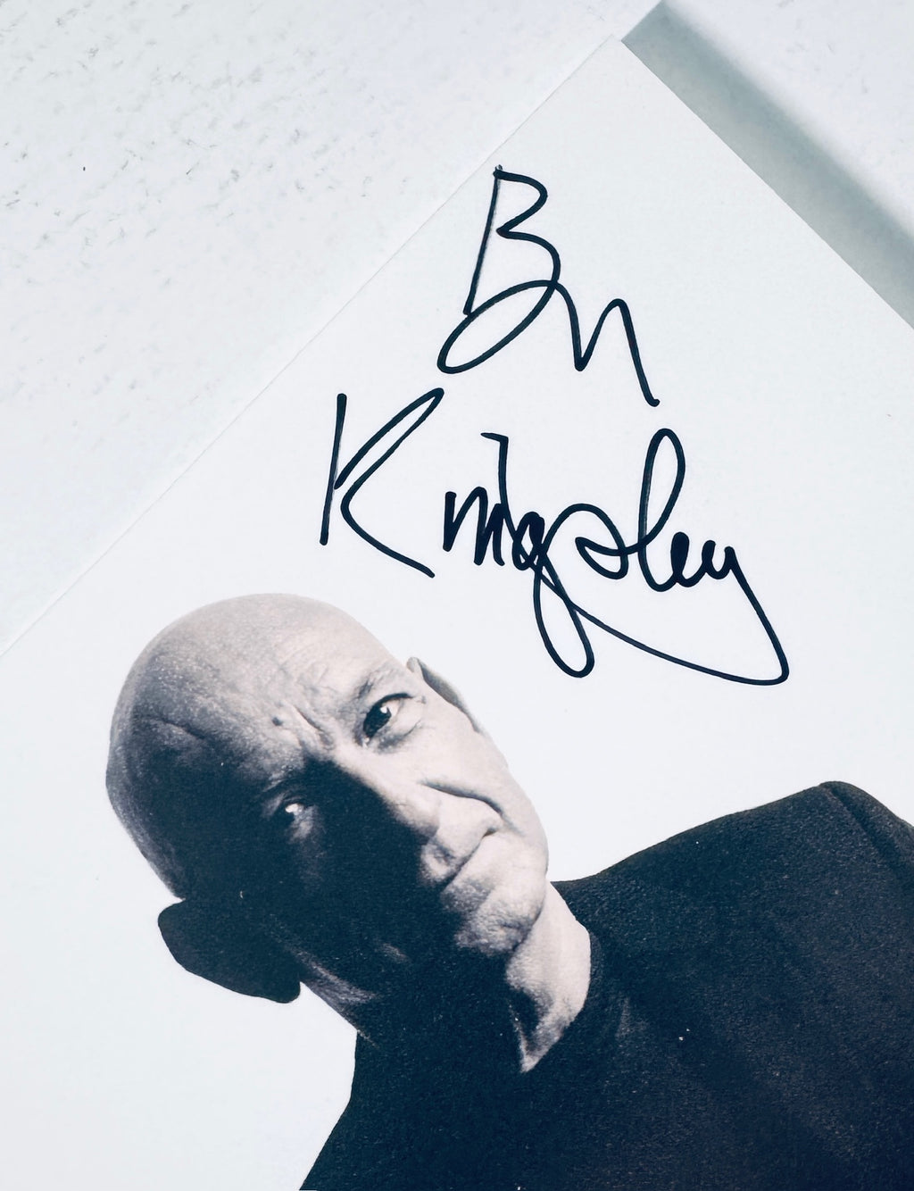 Angled close-up detail of Ben Kingsley signature in black marker on light background.