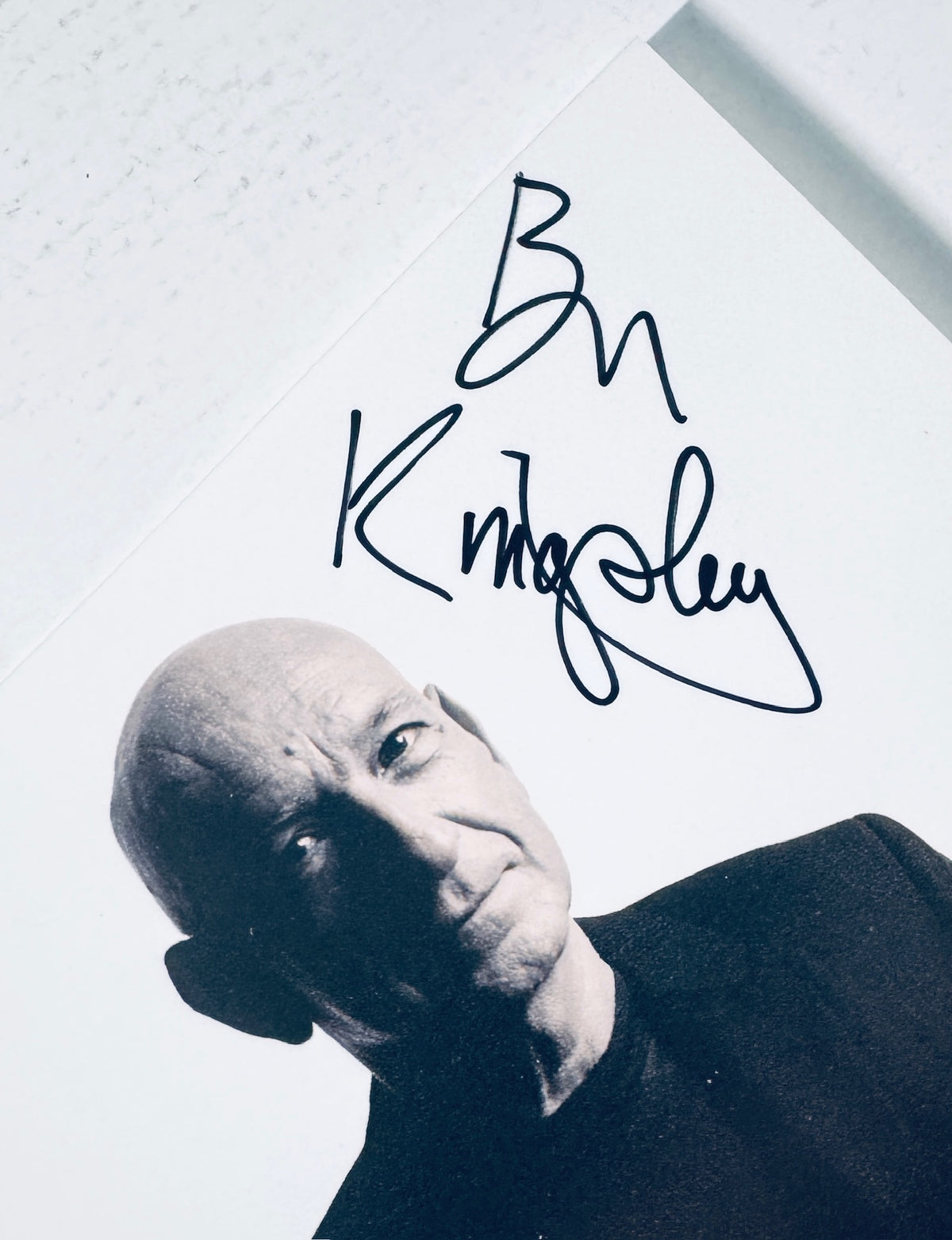 Angled close-up detail of Ben Kingsley signature in black marker on light background.