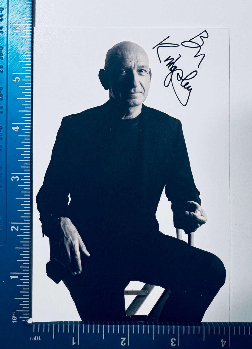 Autographed Ben Kingsley black and white photograph positioned next to a measuring ruler for scale.