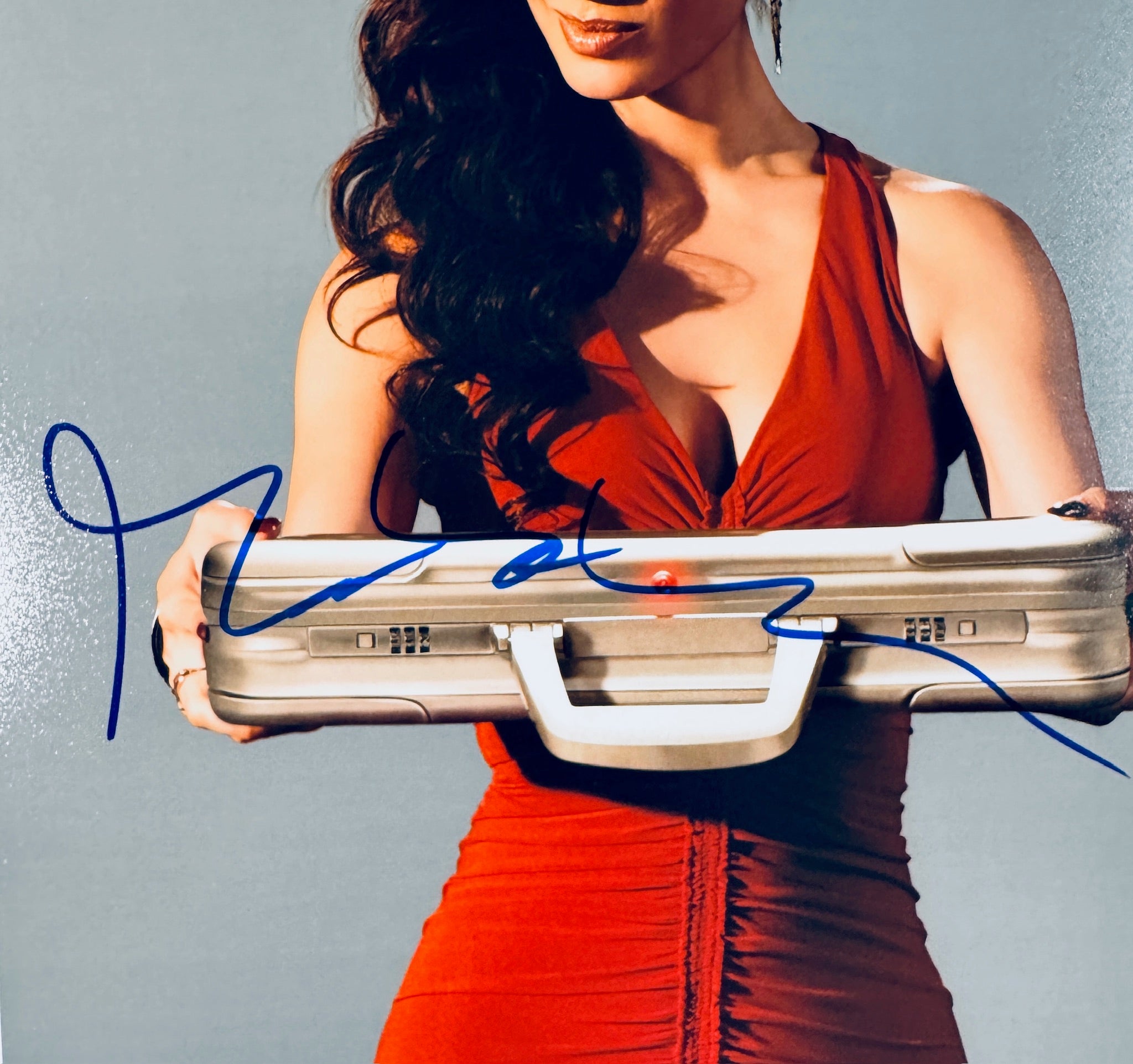 Close-up view of the blue autograph of Bernice Marlohe, the James Bond girl from Skyfall, across the front of the promotional photograph.