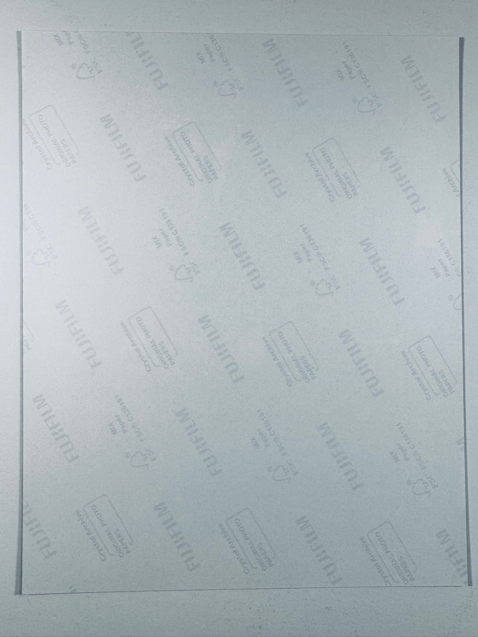 he plain white reverse side of a photographic print showing translucent Fujifilm crystal archive paper watermarks and logos.