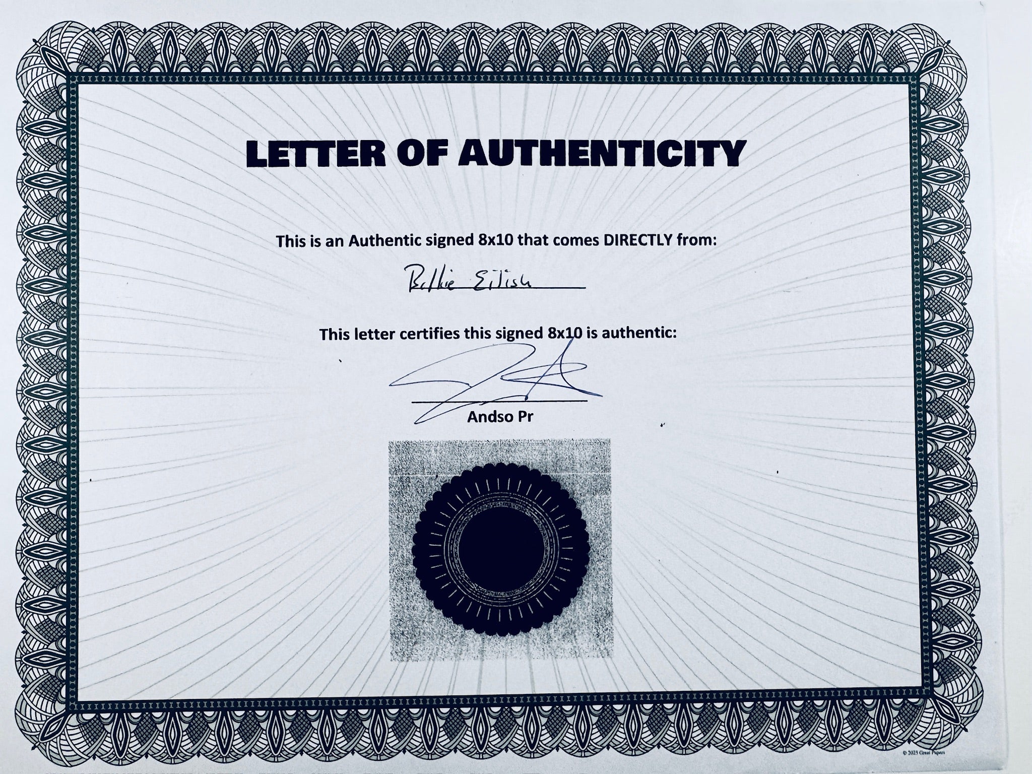 A Certificate of Authenticity featuring a decorative blue-patterned border, text certifying an authentic signed 8x10 from Billie Eilish, a signature, and a dark circular seal graphic at the bottom center.