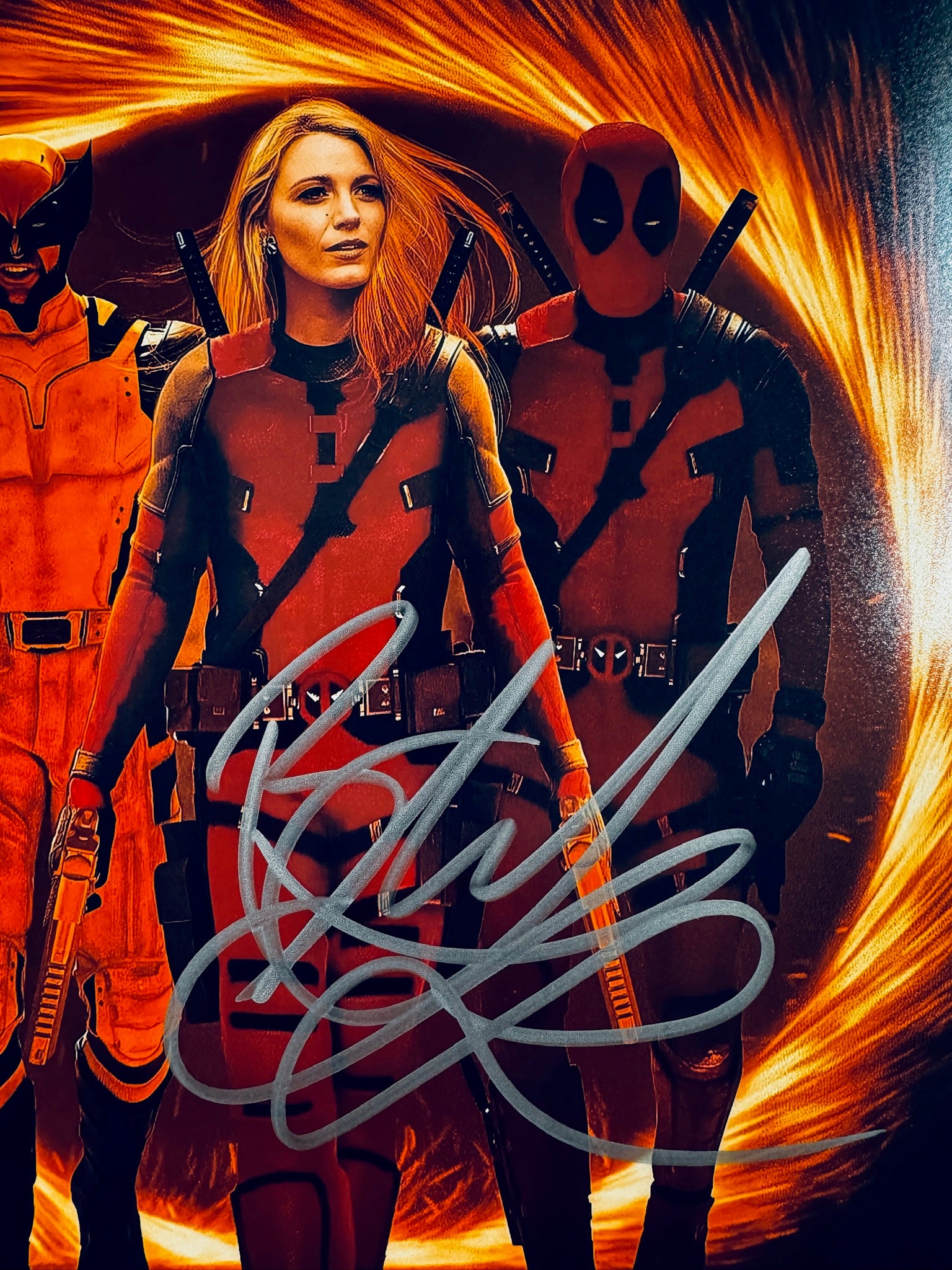 Close-up view of Blake Lively's signature in silver marker across the Deadpool and Wolverine matte promotional photo.