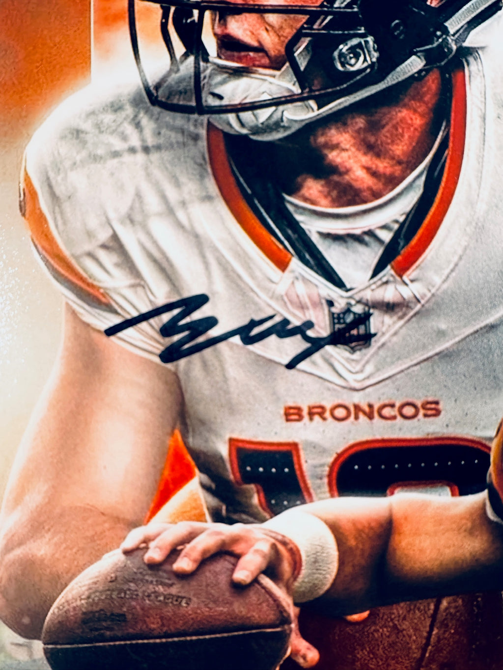 Close-up view of Bo Nix's signature across the jersey front of the Denver Broncos promotional photograph.