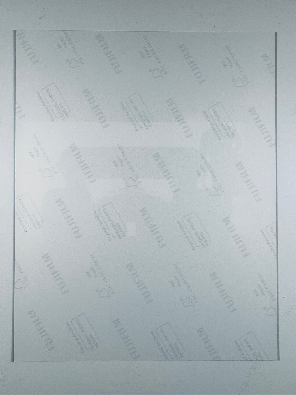 The plain white reverse side of a photographic print showing translucent Fujifilm crystal archive paper watermarks and logos.