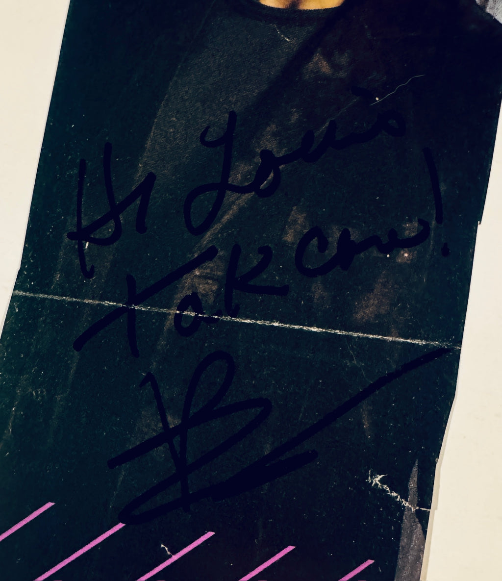 Close-up of Bradley Cooper hand-signed autograph inscribed 'Hi Louis Take care! B' in black sharpie.