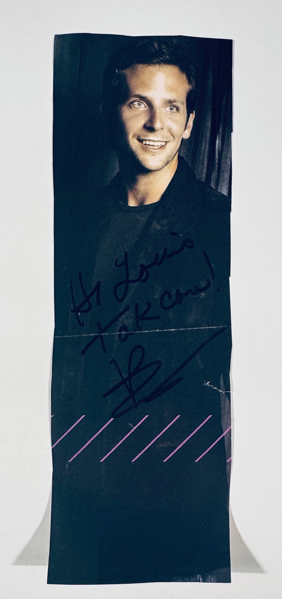 Full front view of tall rectangular magazine clipping autographed by Bradley Cooper.