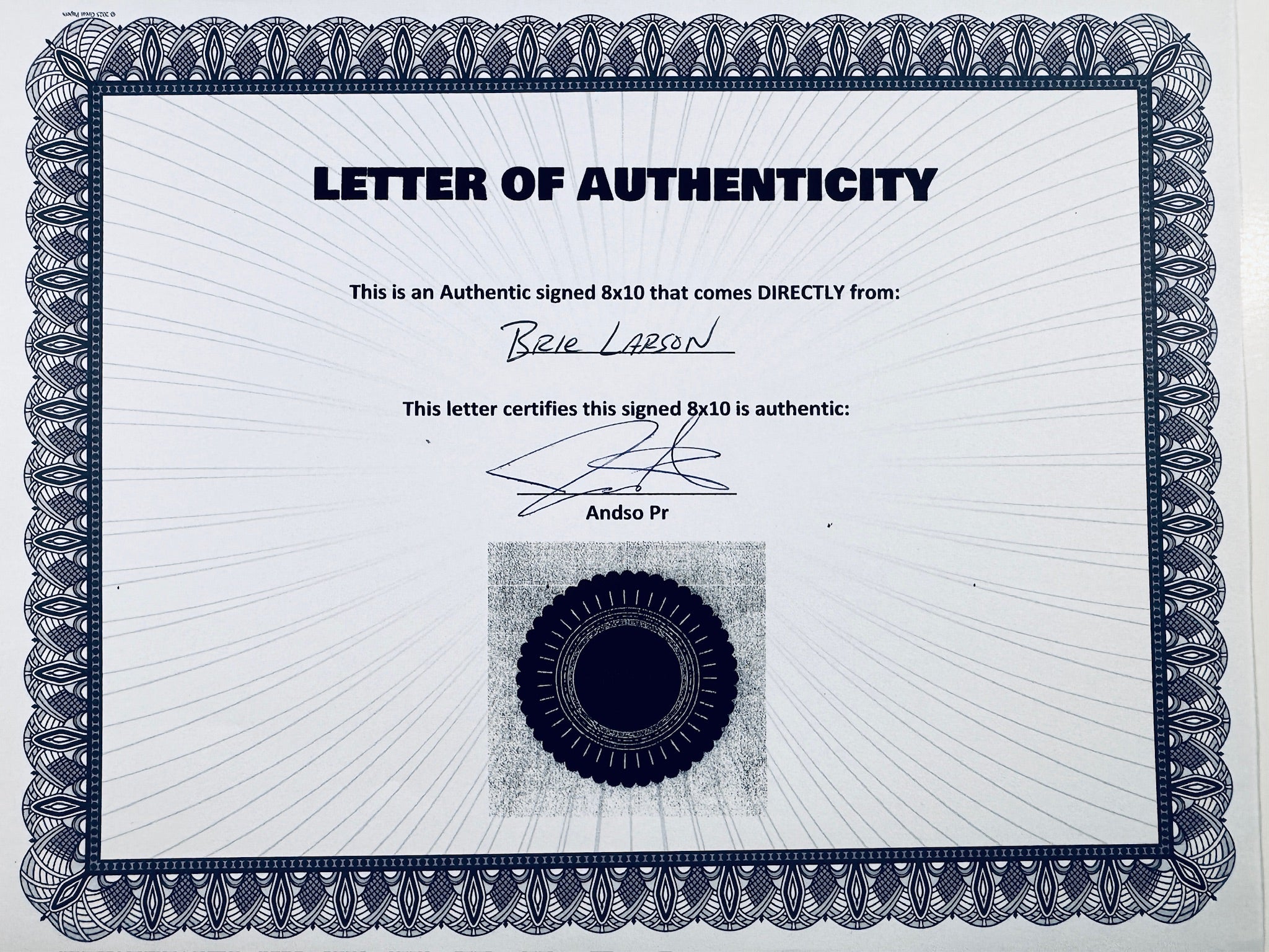 A Letter of Authenticity with a decorative blue-patterned border, certifying an authentic signed 8x10 coming directly from Brie Larson, featuring a dark circular seal graphic at the bottom.