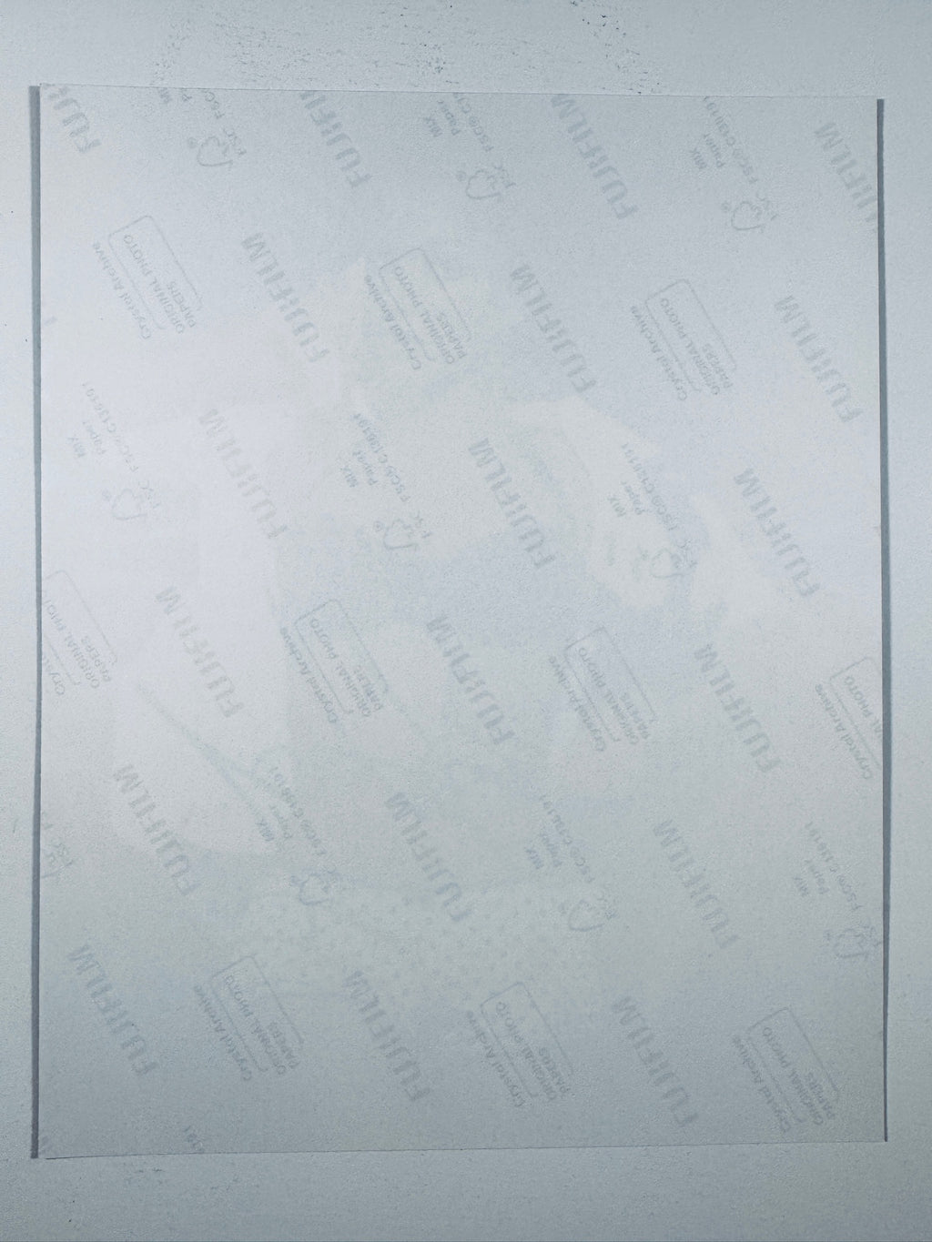 The plain white reverse side of a photographic print showing translucent Fujifilm crystal archive paper watermarks and logos.