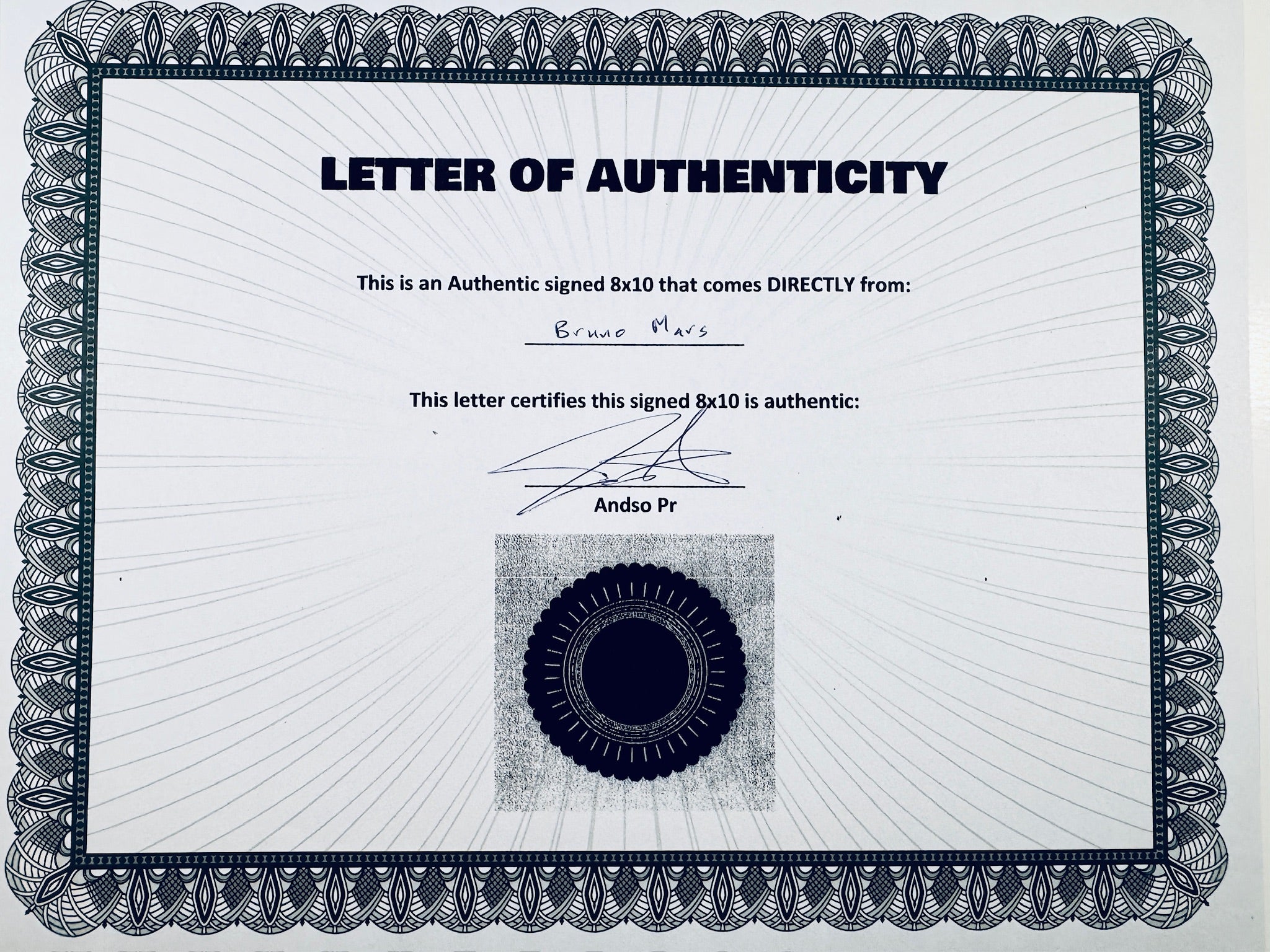 A Letter of Authenticity with a decorative blue-patterned border, certifying an authentic signed 8x10 coming directly from Bruno Mars, featuring a dark circular seal graphic at the bottom.