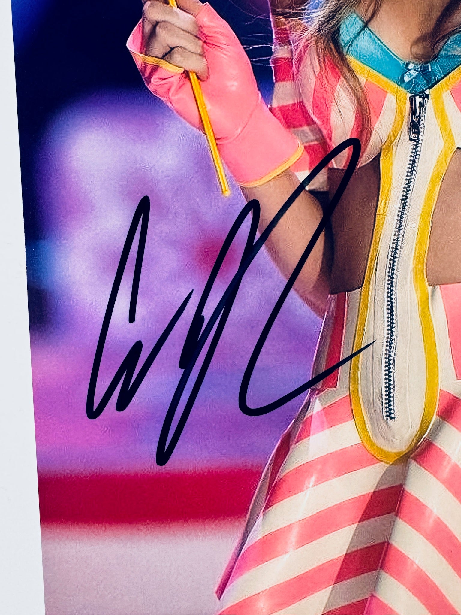 Close-up of Cara Delevingne's signature in black marker on the signed runway 8x10 photo.