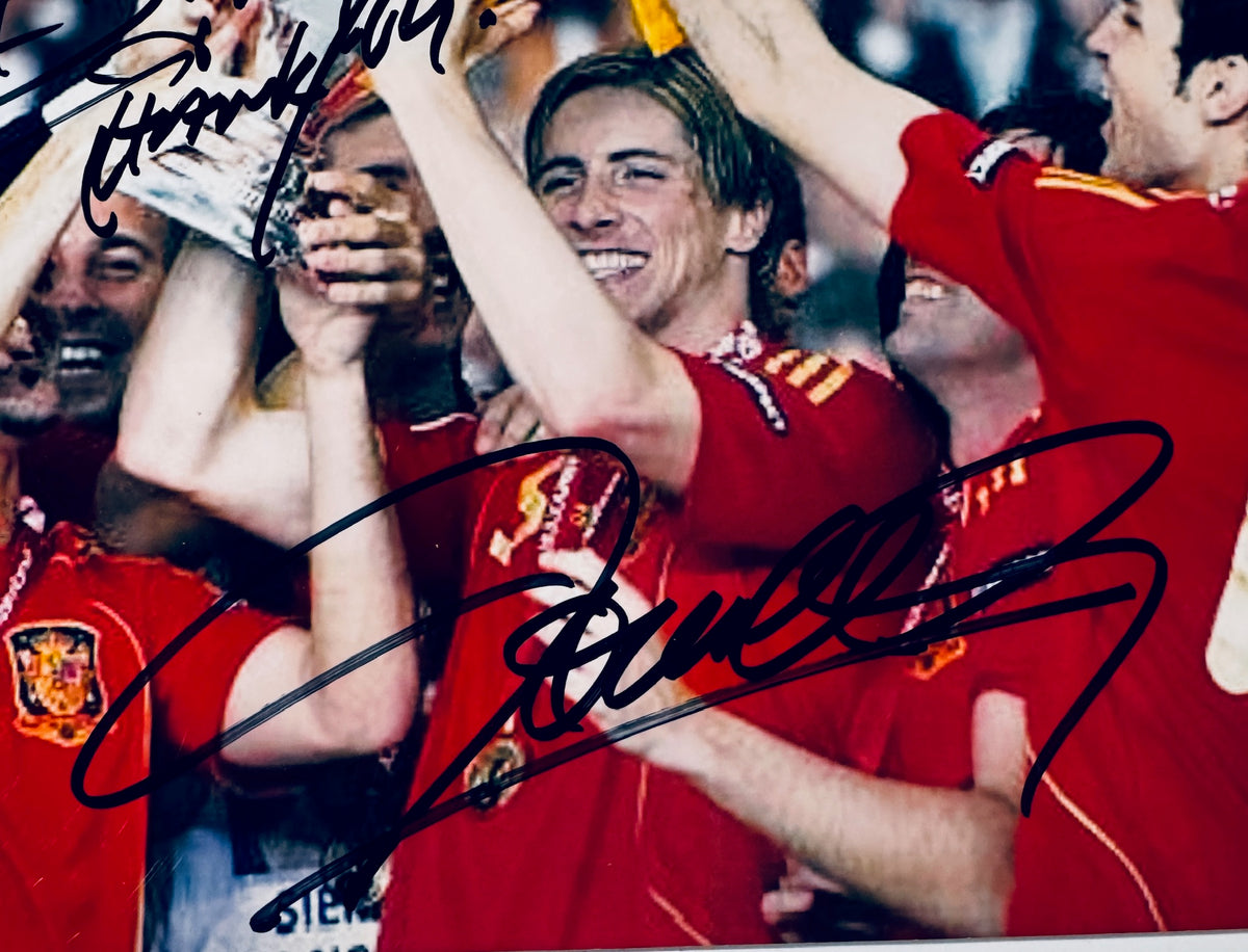 Macro close-up detail of Carles Puyol signature written in bold black marker across the front of the photo.