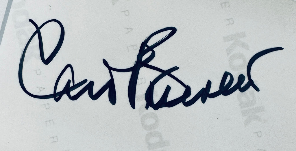 Close-up view of Carol Burnett autograph in black sharpie on the back of Kodak paper.