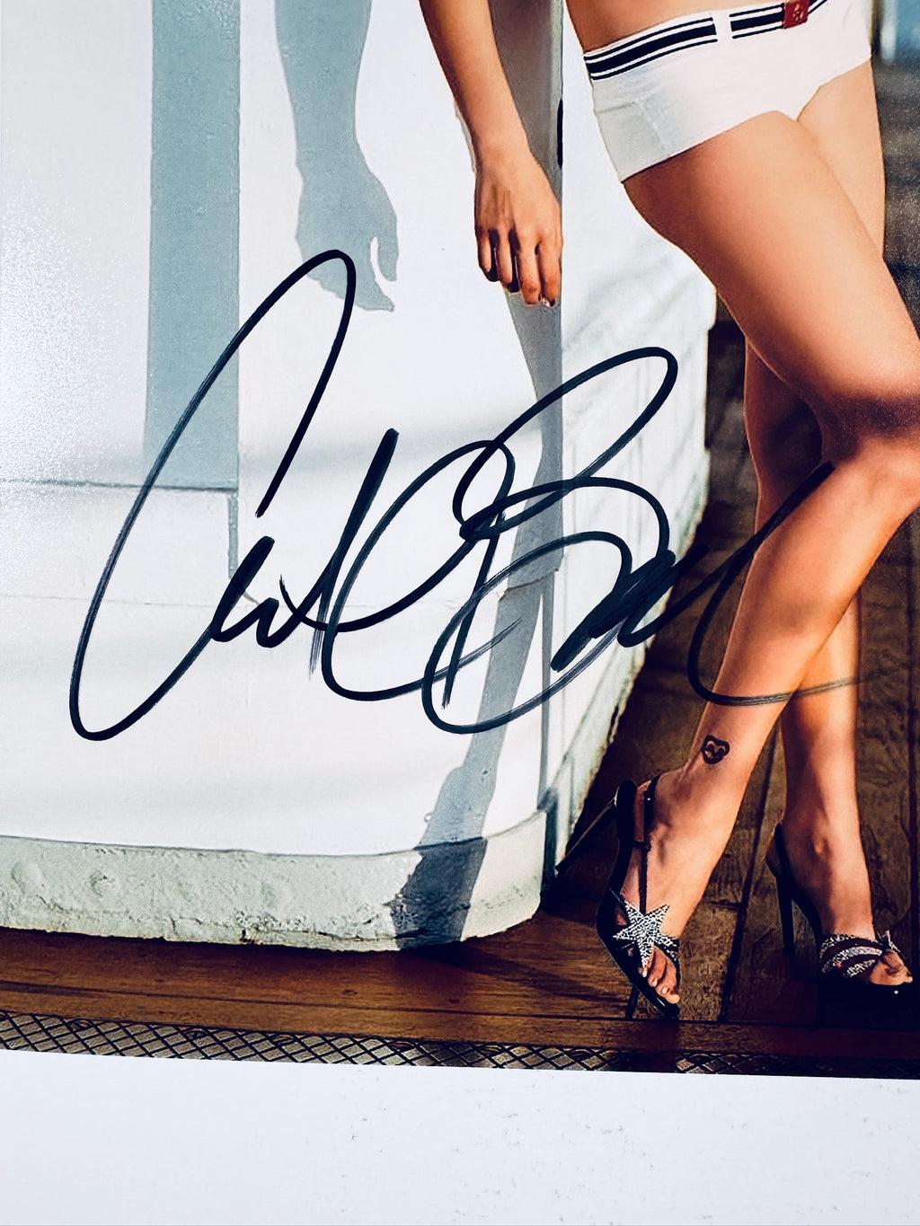 Close-up view of Catherine Bell's black autograph across the lower portion and legs on the promotional photograph.