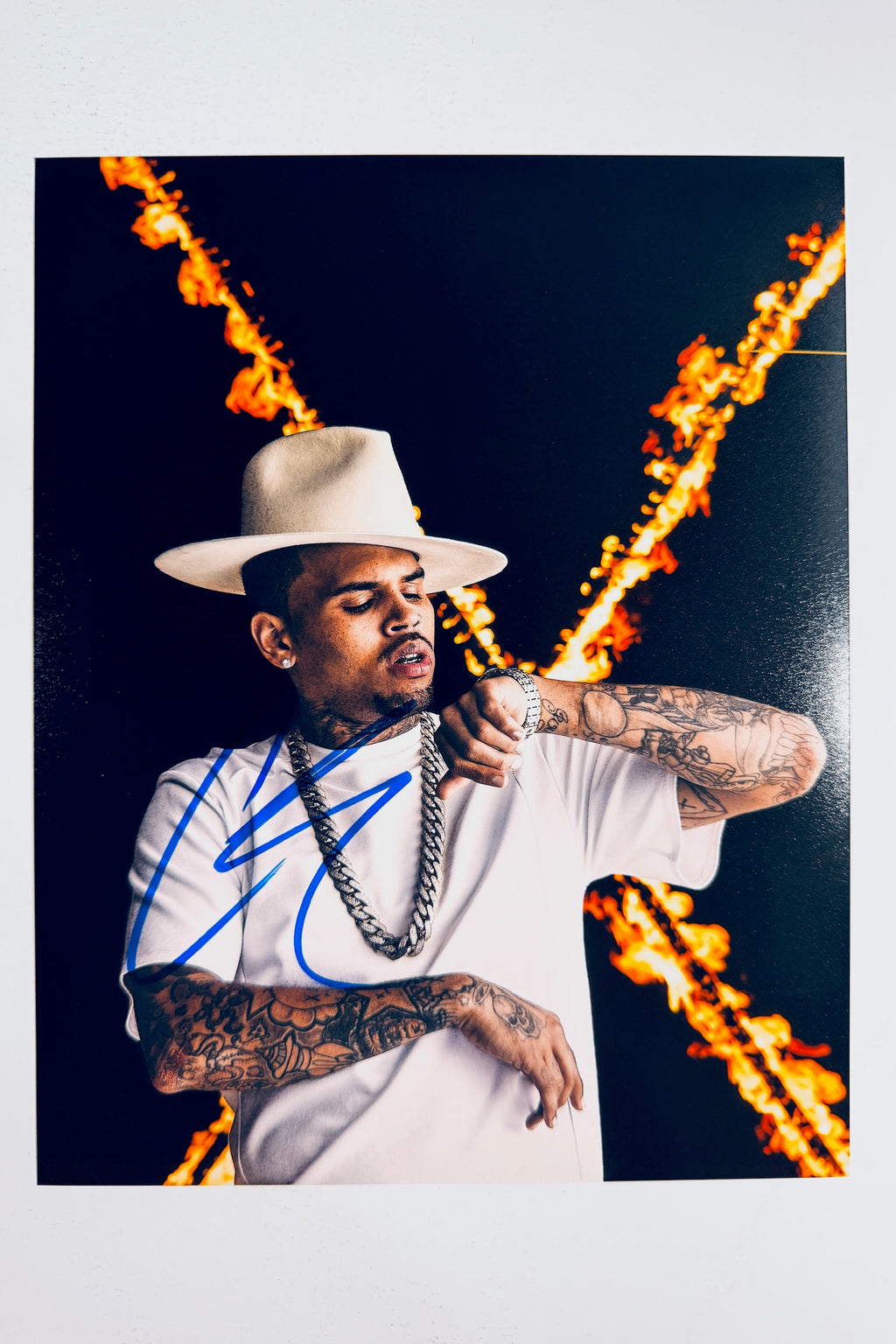 Chris Brown hand-signed 8x10 matte photo in a white hat and chain against a fiery background.