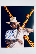 Chris Brown hand-signed 8x10 matte photo in a white hat and chain against a fiery background.