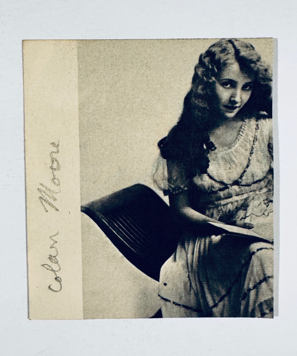 Vintage 1920s black and white magazine clipping portrait of silent movie star Colleen Moore in a lace gown, featuring a printed vertical border margin with her name.