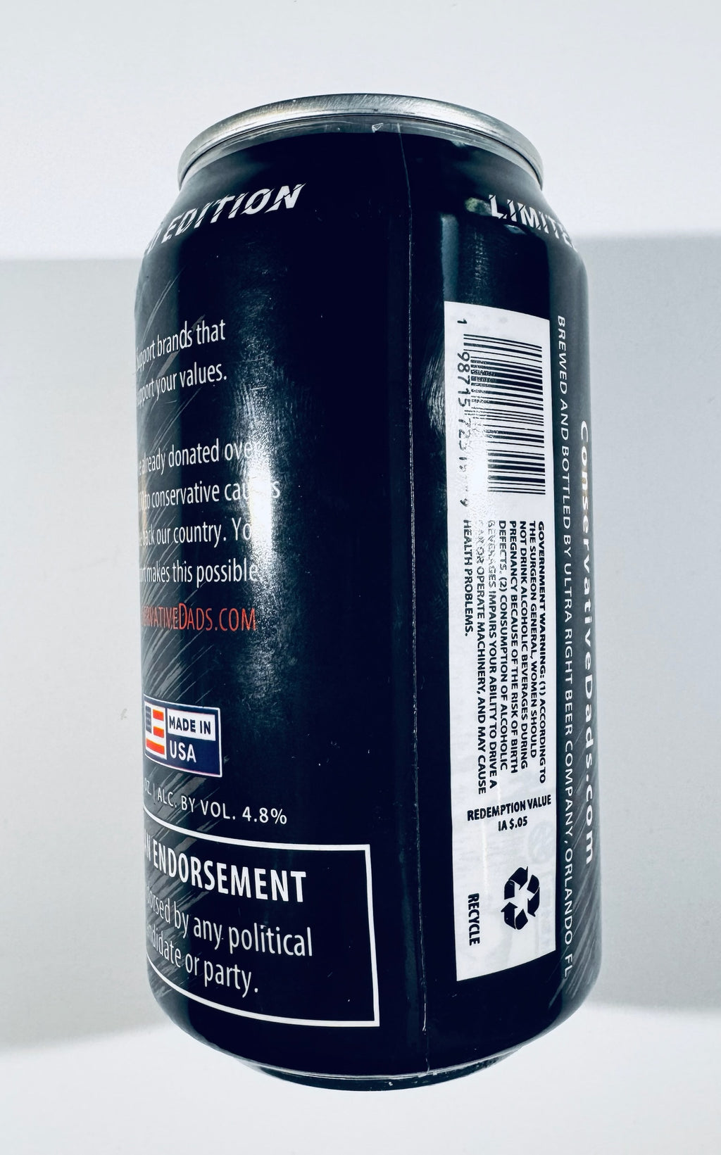 A black aluminum beverage can shown from the side against a plain light background, with white text and a barcode label visible on the can.