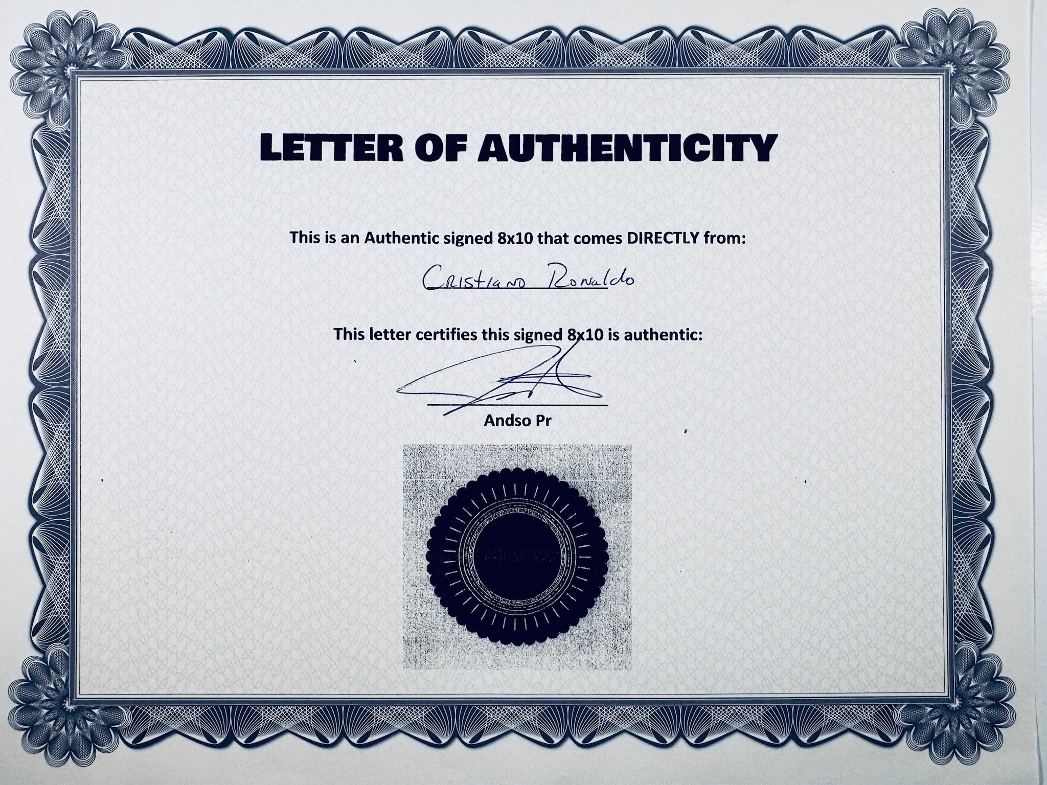 A Letter of Authenticity with a decorative blue-patterned border, certifying an authentic signed 8x10 coming directly from Cristiano Ronaldo, featuring a dark circular seal graphic at the bottom.