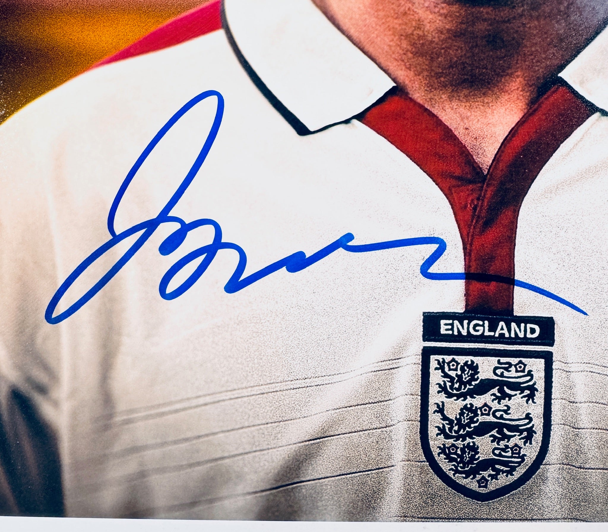 Close-up of David Beckham's signature in blue marker on the signed England 8x10 photo.