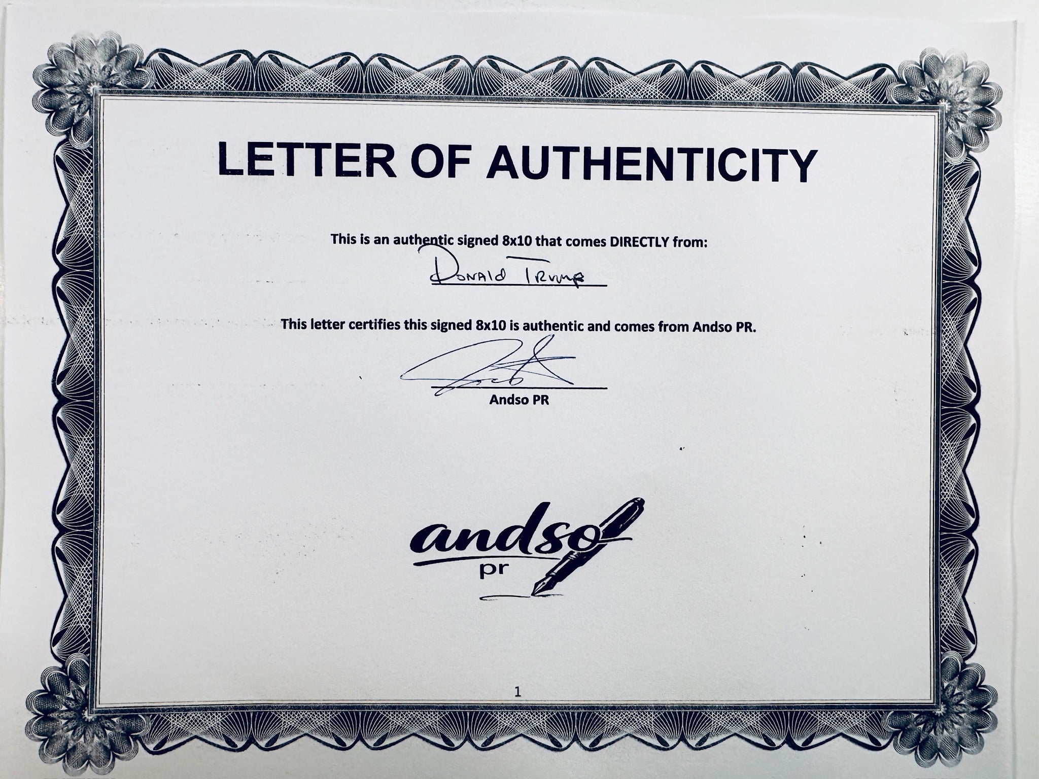 A Letter of Authenticity with a decorative blue-patterned border, certifying an authentic signed 8x10 coming directly from Donald Trump, featuring a signature at the top.