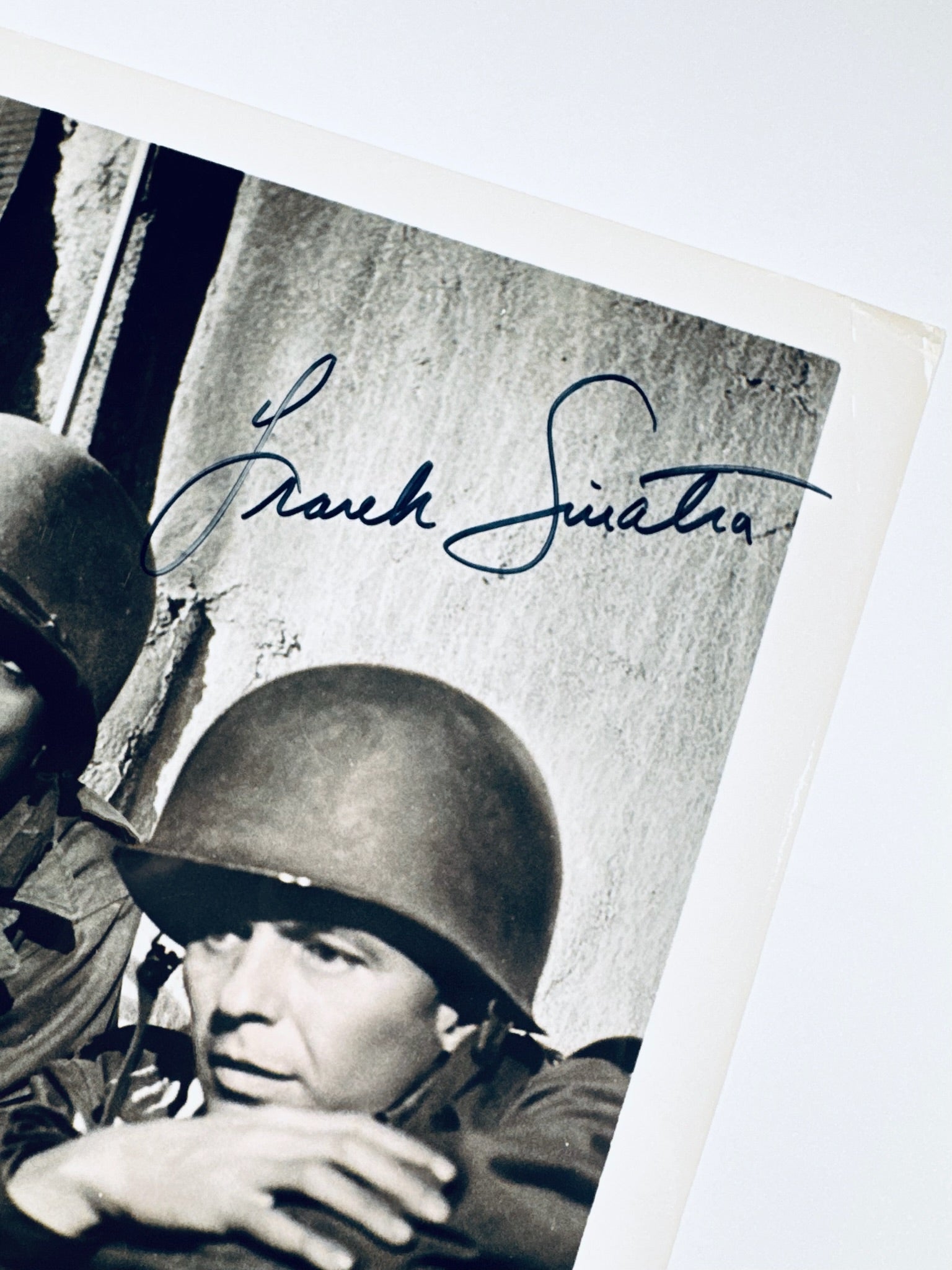 A clear, close-up view showing the authentic hand-signed signature of Frank Sinatra on a vintage photograph.
