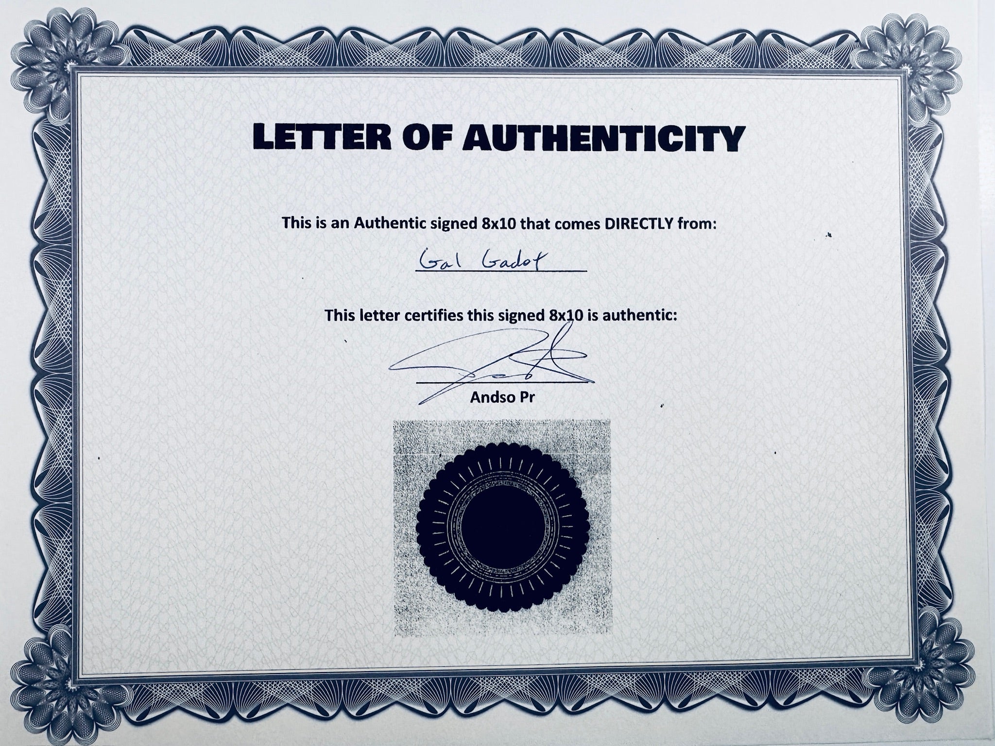 A Letter of Authenticity with a decorative blue-patterned border, certifying an authentic signed 8x10 coming directly from Gal Gadot, featuring a dark circular seal graphic at the bottom.