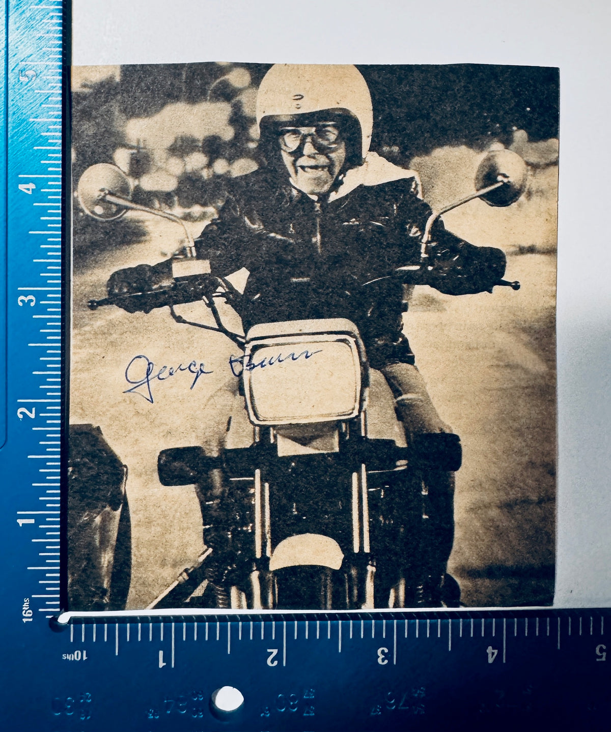 George Burns autographed motorcycle photo measured with precision ruler showing dimensions approx 4x5 inches.