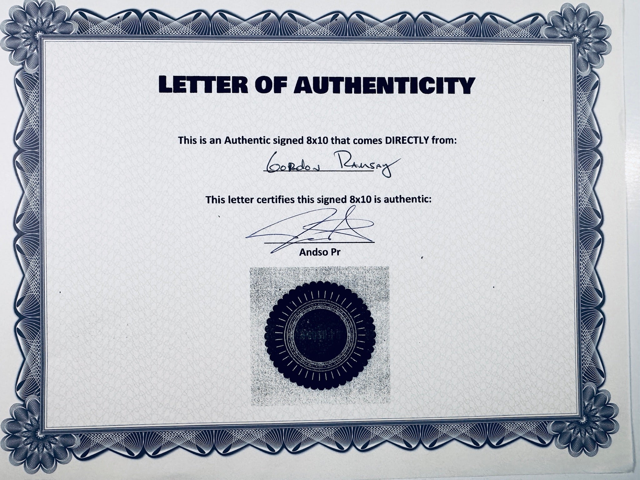 A Letter of Authenticity with a decorative blue-patterned border, certifying an authentic signed 8x10 coming directly from Gordon Ramsay, featuring a dark circular seal graphic at the bottom.