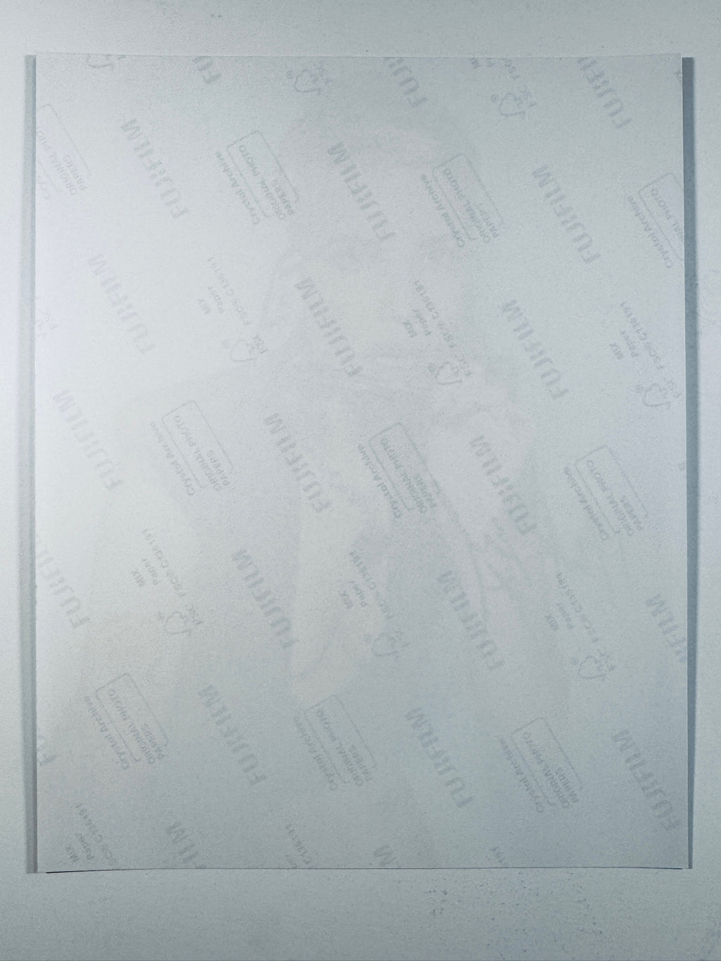 The plain white reverse side of a photographic print showing translucent Fujifilm crystal archive paper watermarks and logos.
