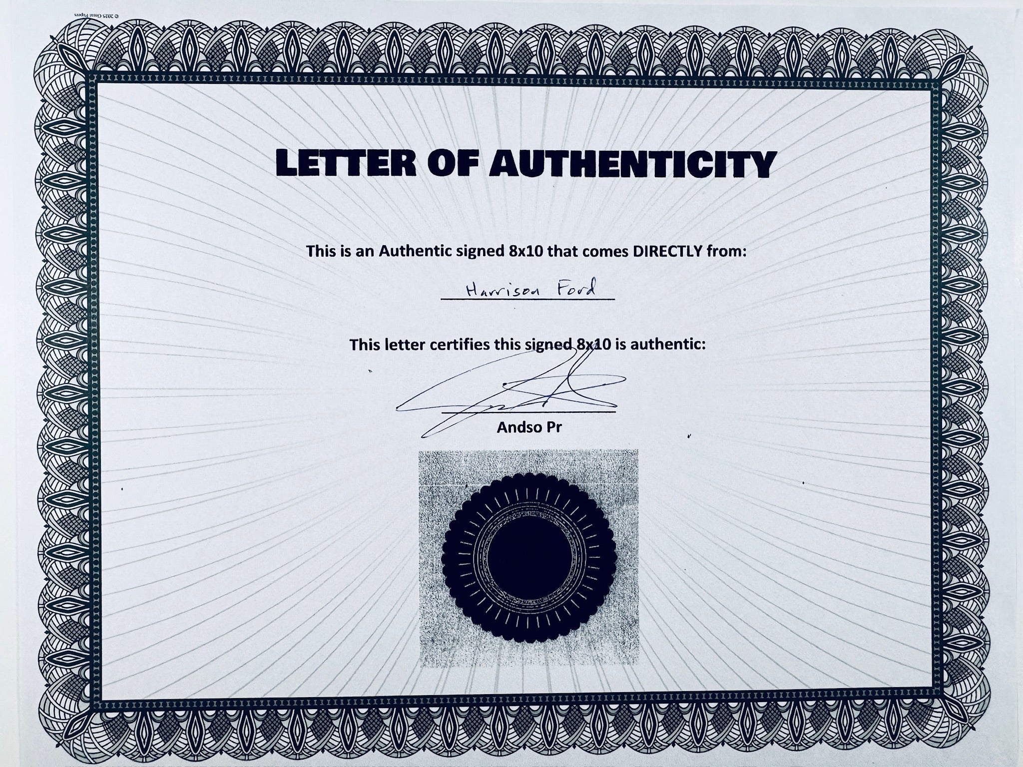 A Certificate of Authenticity featuring a decorative blue-patterned border, text certifying an authentic signed 8x10 from Harrison Ford, a signature, and a dark circular seal graphic at the bottom center.