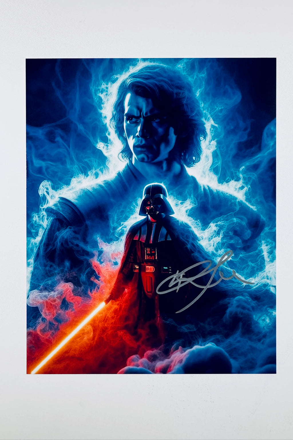 A stylized artwork depicting Darth Vader standing with a glowing red lightsaber against a blue and red smoky background, with a translucent ghost-like image of Anakin Skywalker above him, and an autograph on the right side.