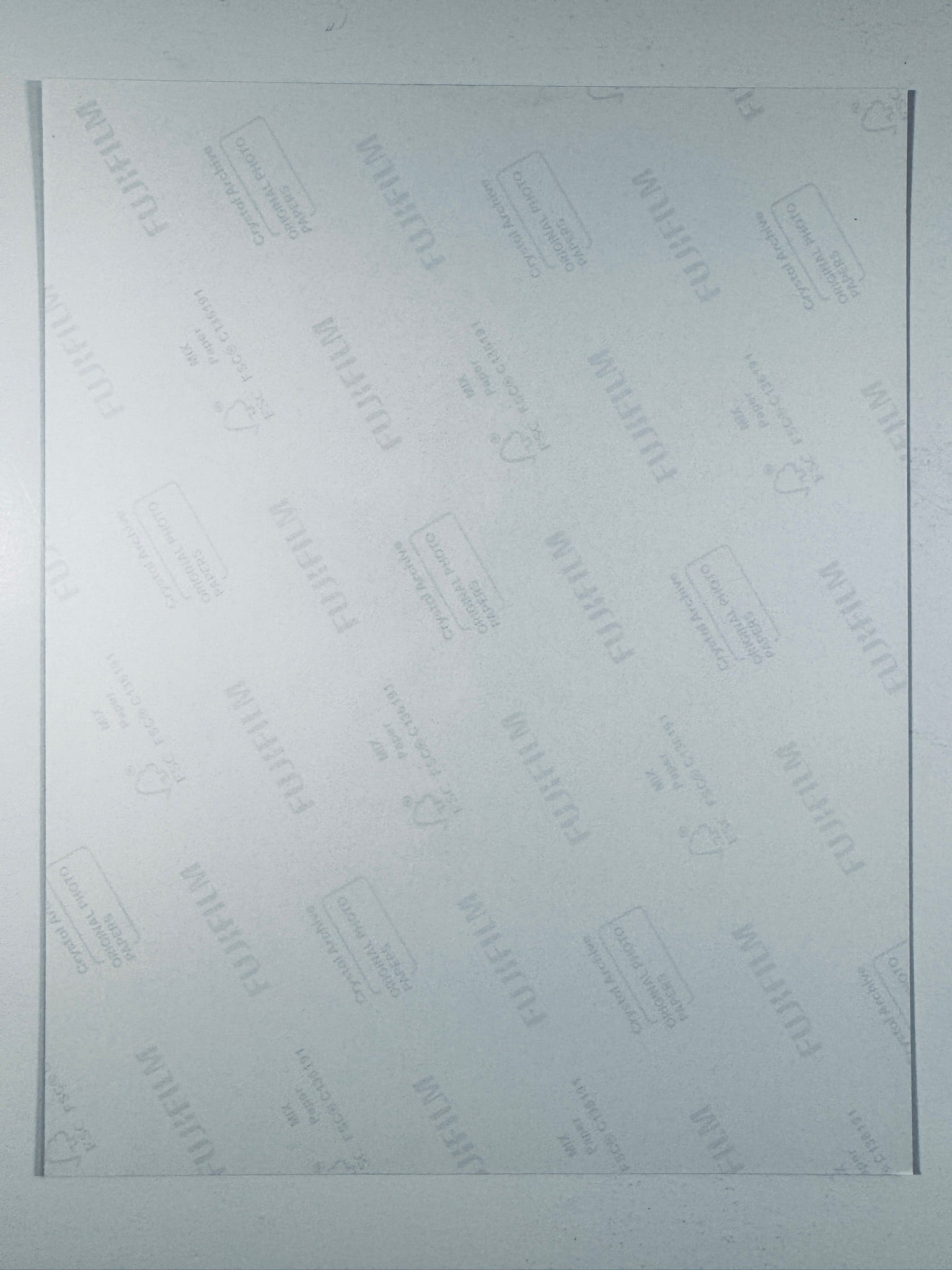 The plain white reverse side of a photographic print showing translucent Fujifilm crystal archive paper watermarks and logos.
