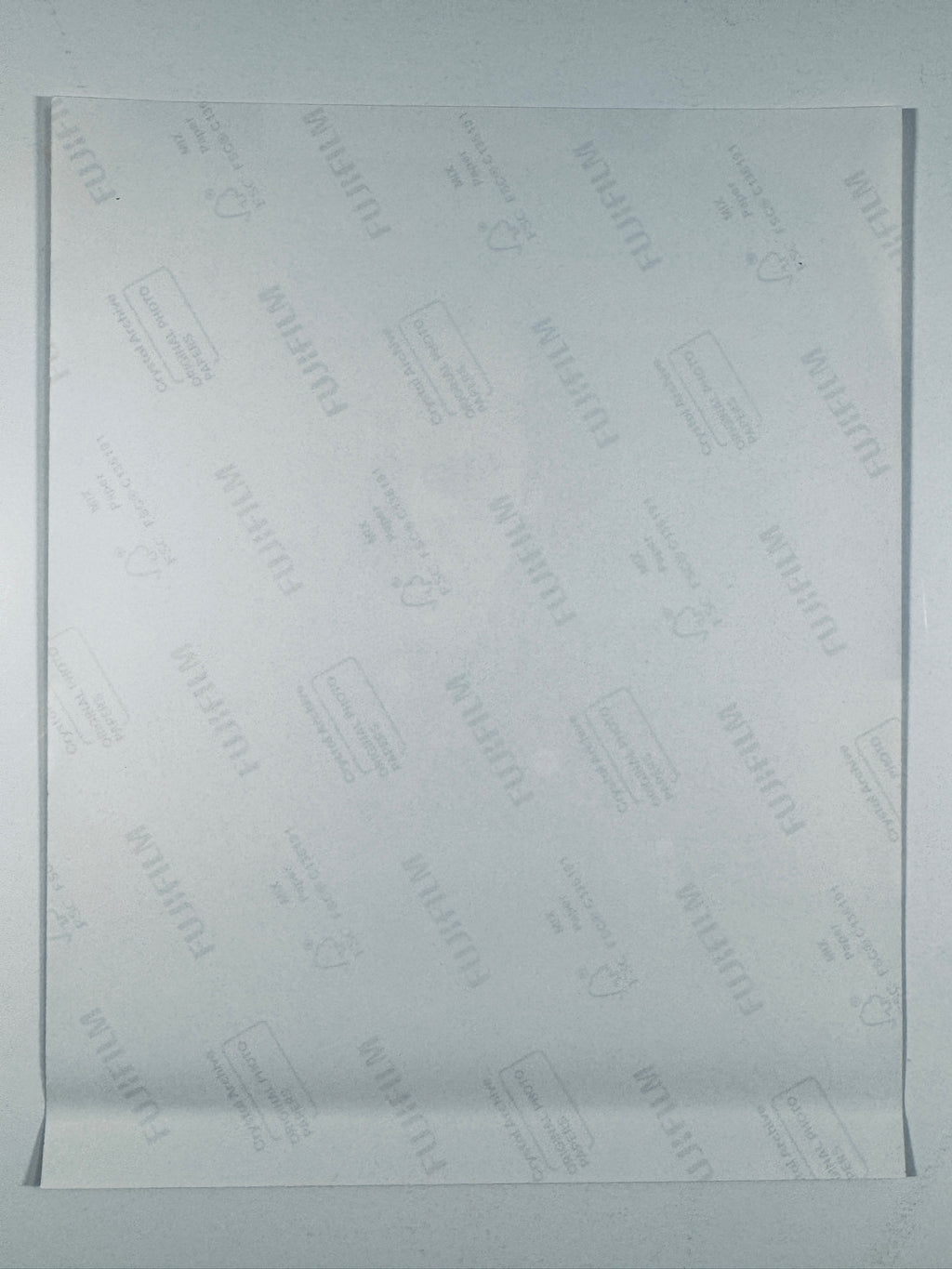 The plain white reverse side of a photographic print showing translucent Fujifilm crystal archive paper watermarks and logos.