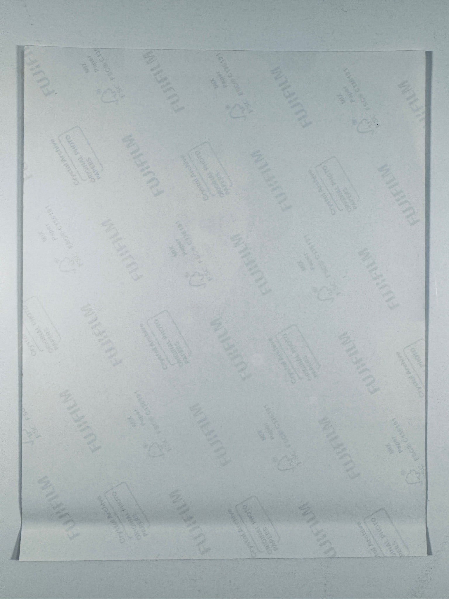 The plain white reverse side of a photographic print showing translucent Fujifilm crystal archive paper watermarks and logos.