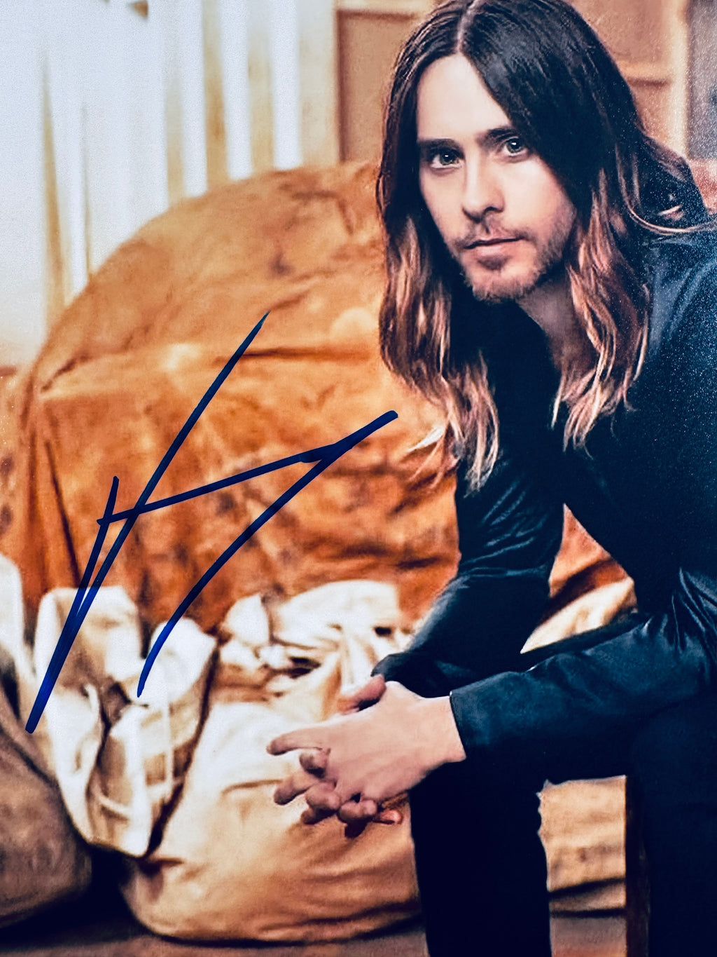 Close-up view of Jared Leto's signature in blue marker across the matte promotional photo.