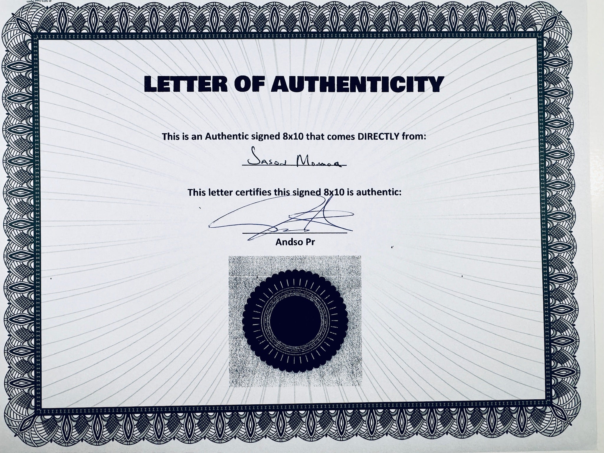 A Letter of Authenticity with a decorative blue-patterned border, certifying an authentic signed 8x10 coming directly from Jason Momoa, featuring a dark circular seal graphic at the bottom.