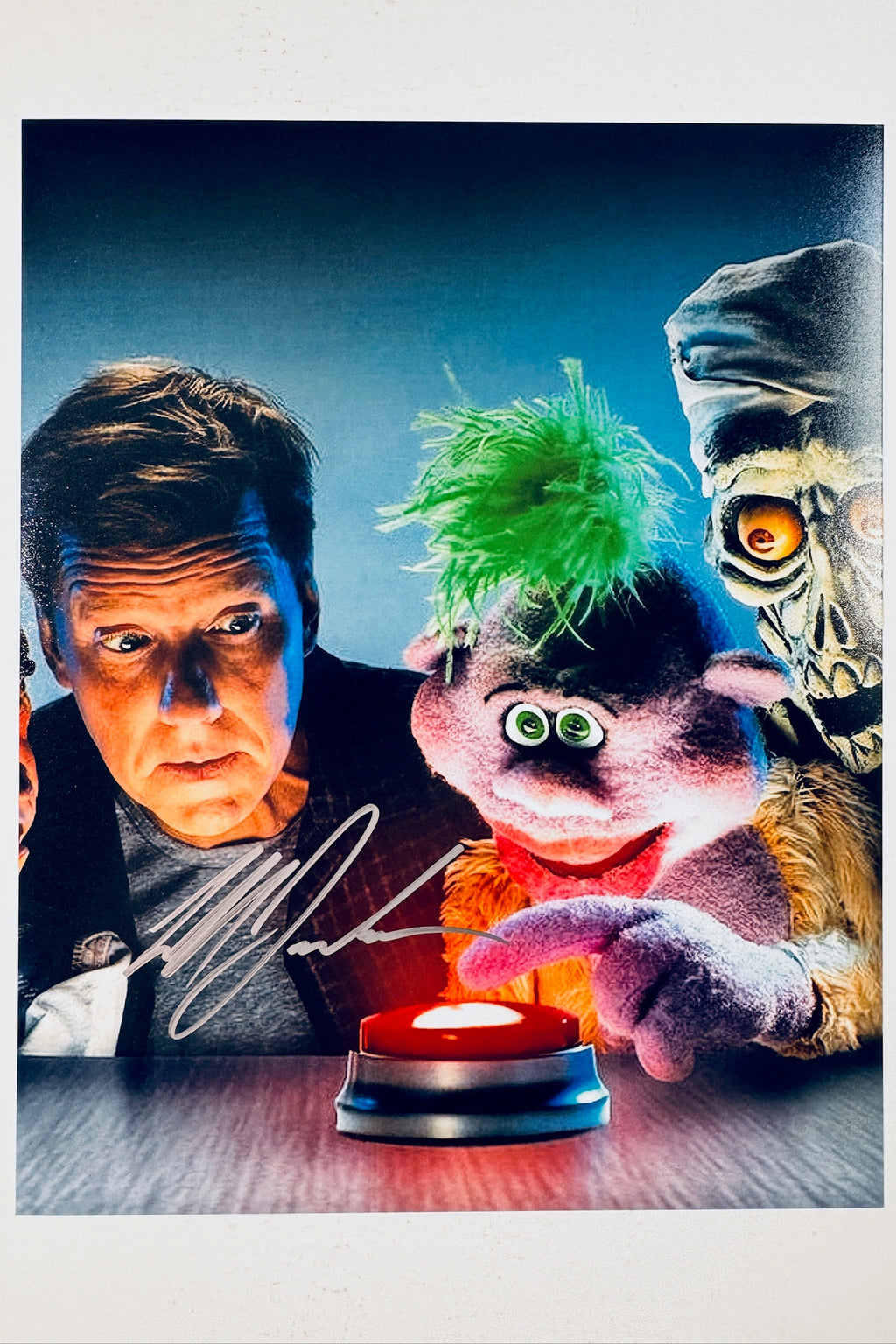 Signed 8x10 matte promotional photo of comedian Jeff Dunham with puppet characters from Crank Yankers looking at a red button, featuring a bold silver ink autograph.