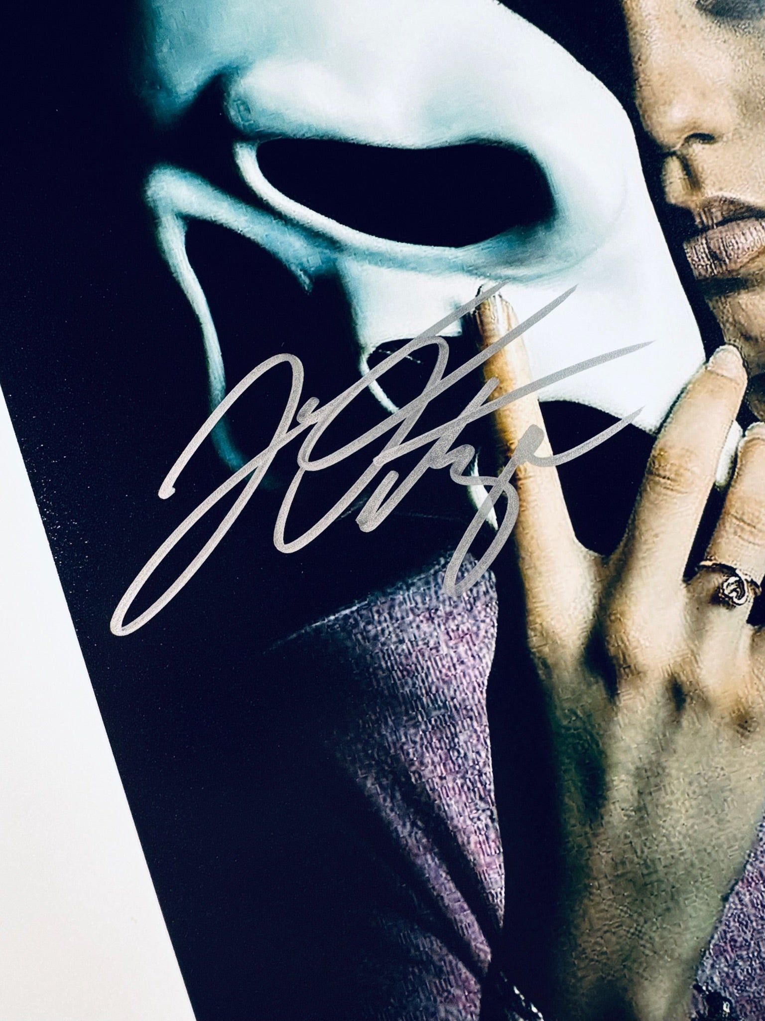 A close-up view showing the authentic hand-signed signature of Jenna Ortega on a photograph.