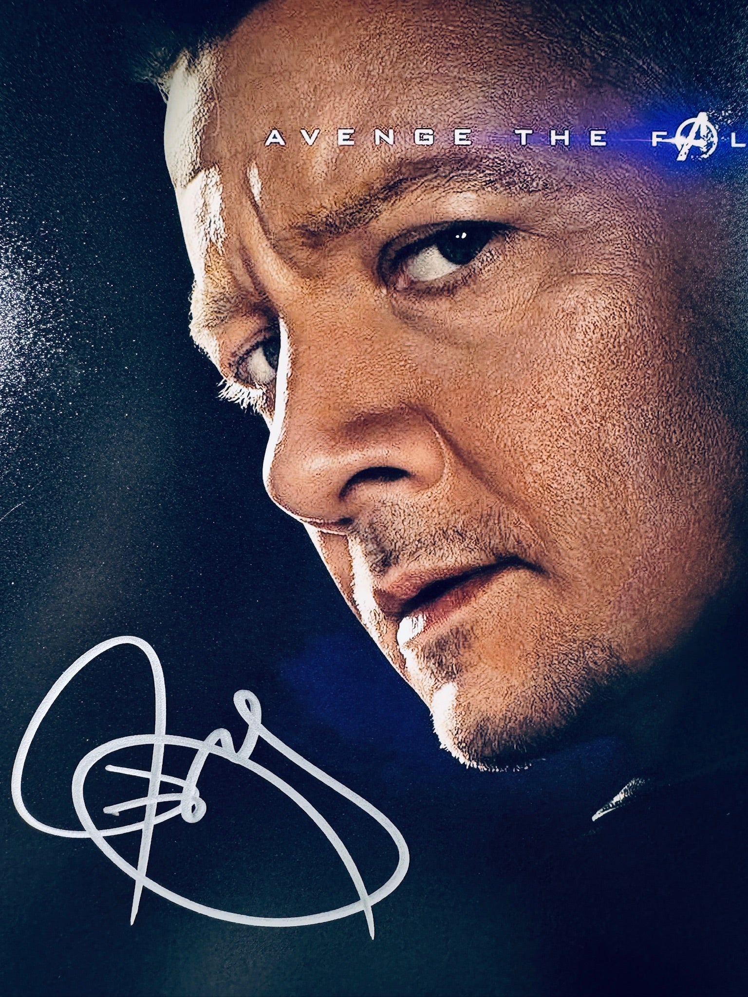 Close-up view of Jeremy Renner's signature in silver marker on the Avengers Endgame promotional matte photo.