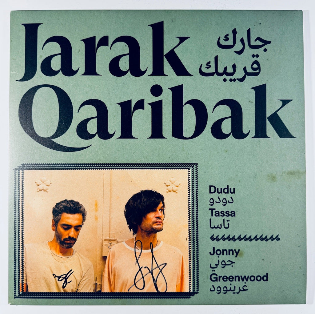 Front cover of the unplayed Jarak Qaribak vinyl record signed by Jonny Greenwood and Dudu Tassa, featuring green artwork and signatures.