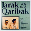 Front cover of the unplayed Jarak Qaribak vinyl record signed by Jonny Greenwood and Dudu Tassa, featuring green artwork and signatures.