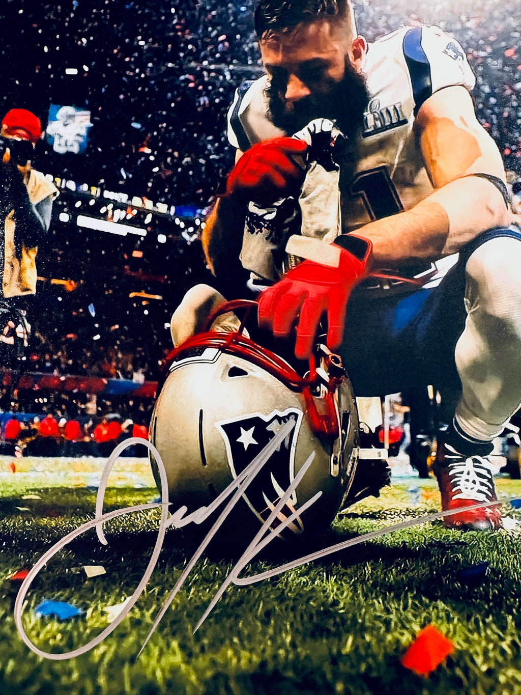 Close-up view of Julian Edelman's signature in silver marker across the New England Patriots promotional matte photo.