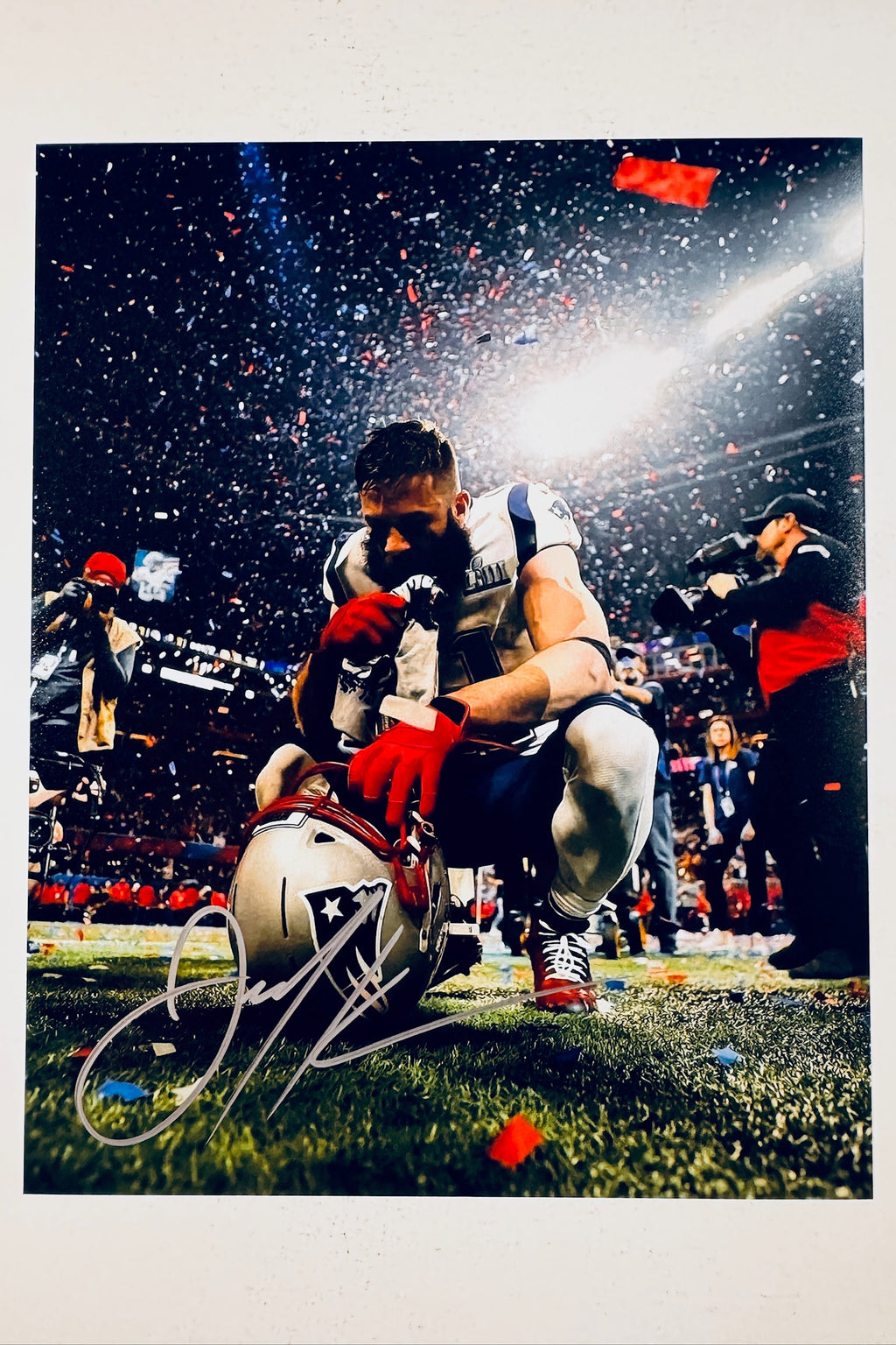 Signed 8x10 matte photo of New England Patriots wide receiver Julian Edelman kneeling on the field with his helmet after a Super Bowl victory, featuring a bold silver ink autograph.