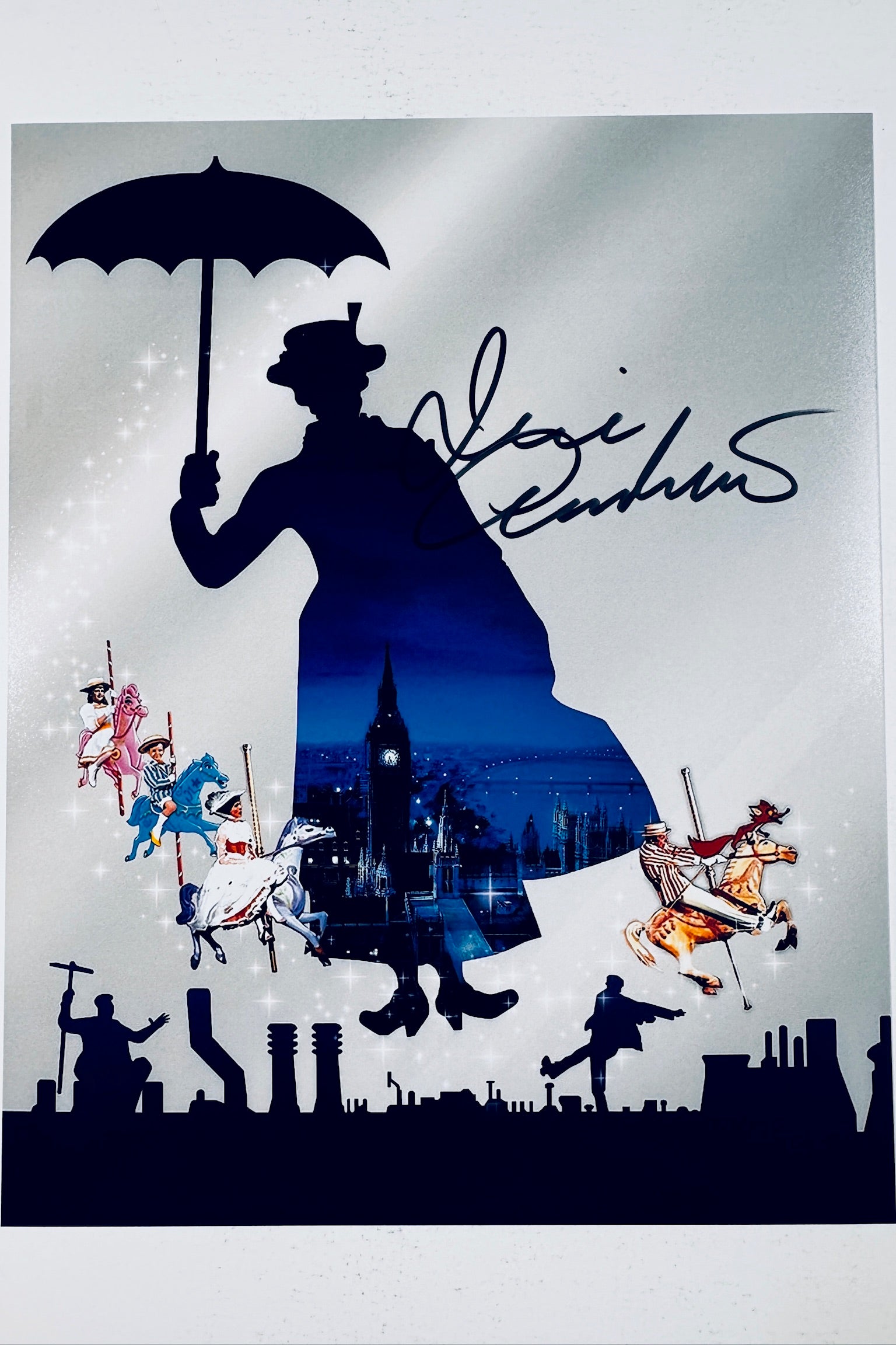 Signed 8x10 matte art print featuring a silhouette of Mary Poppins with London and carousel imagery, featuring a bold black ink autograph by Julie Andrews.